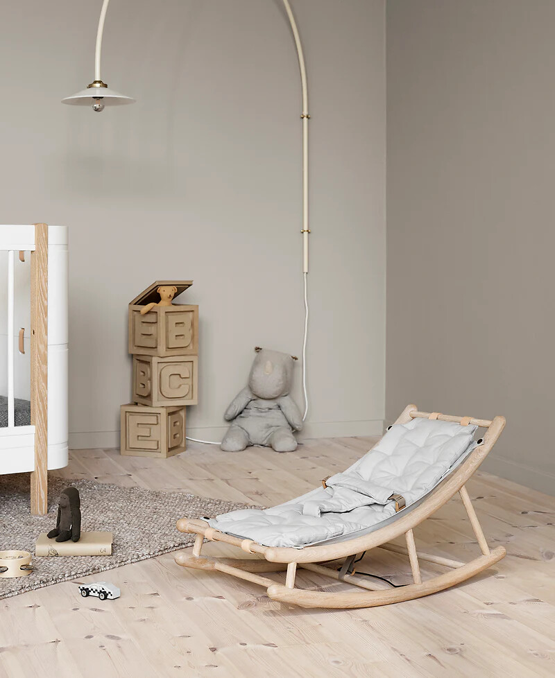 Babywippe aus hellem Holz von Oliver Furniture in modernem Kinderzimmer mit Spielzeug  