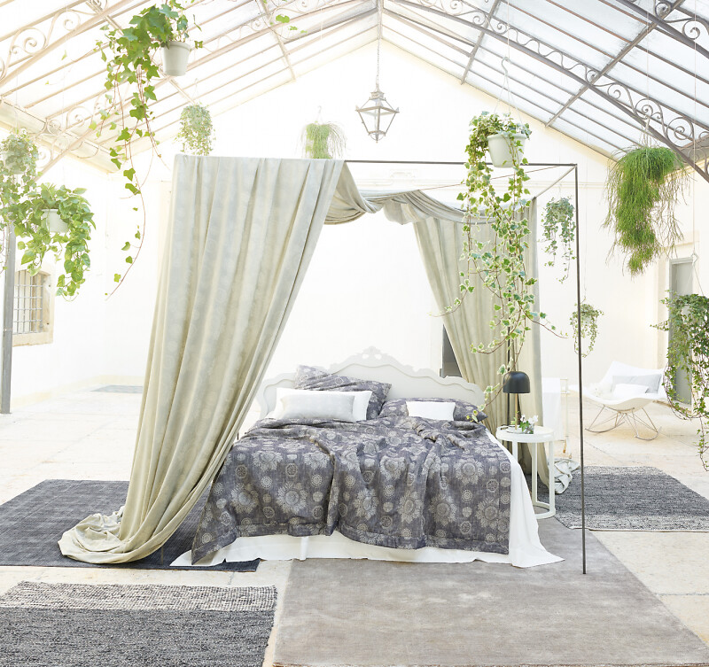 Himmelbett mit floraler Bettwäsche von Leitner Leinen unter lichtdurchfluteter Decke