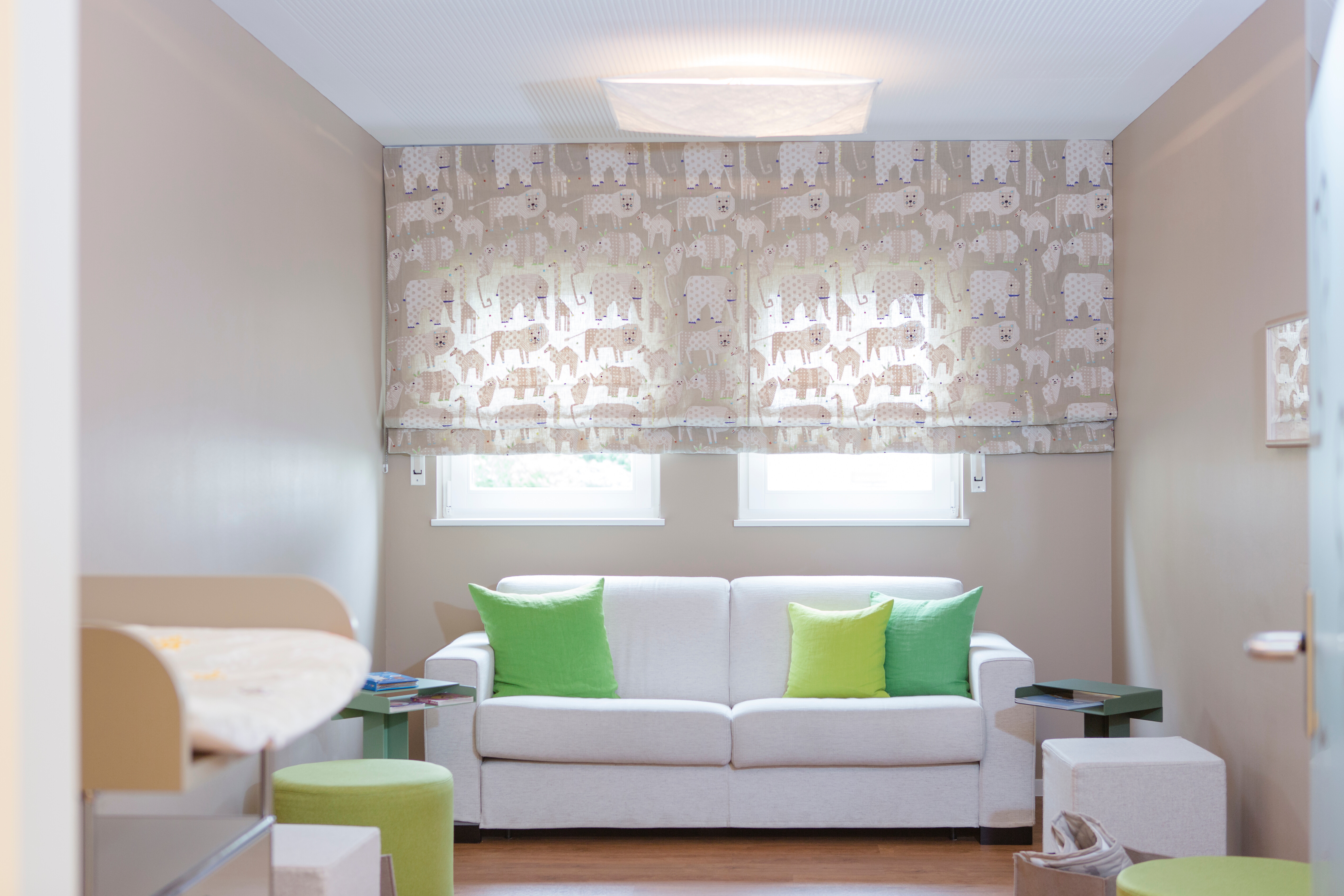 Das warme Licht kombiniert mit Erdtönen verschafft eine gemütliche Atmosphäre im Säuglingswartezimmer.