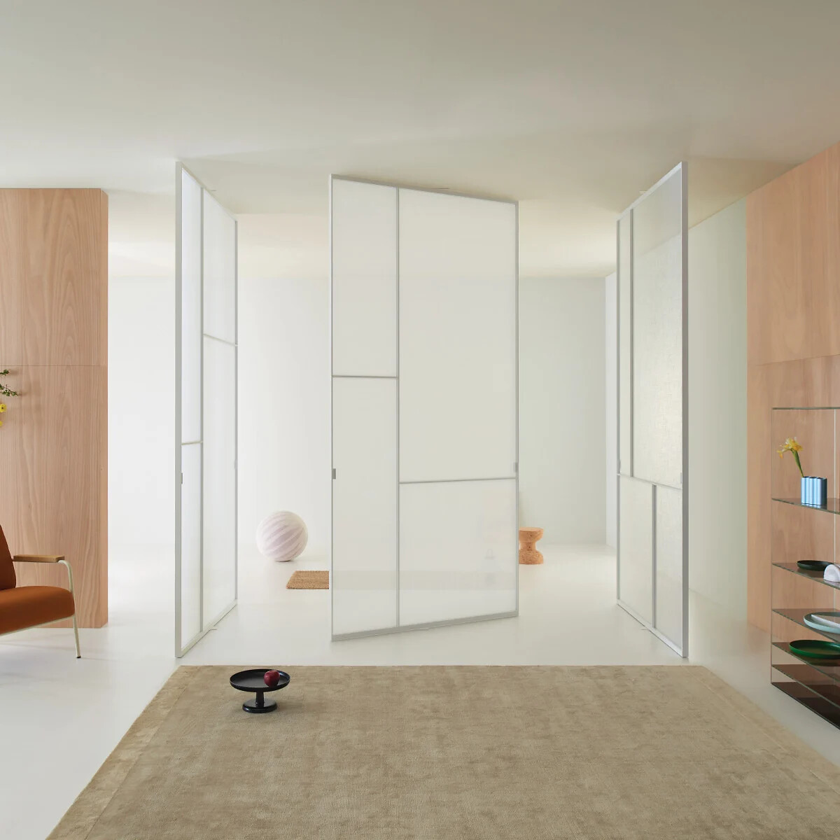 Weiß satinierte Glastüren als bewegliche Raumteiler in einem hellen Wohnraum.