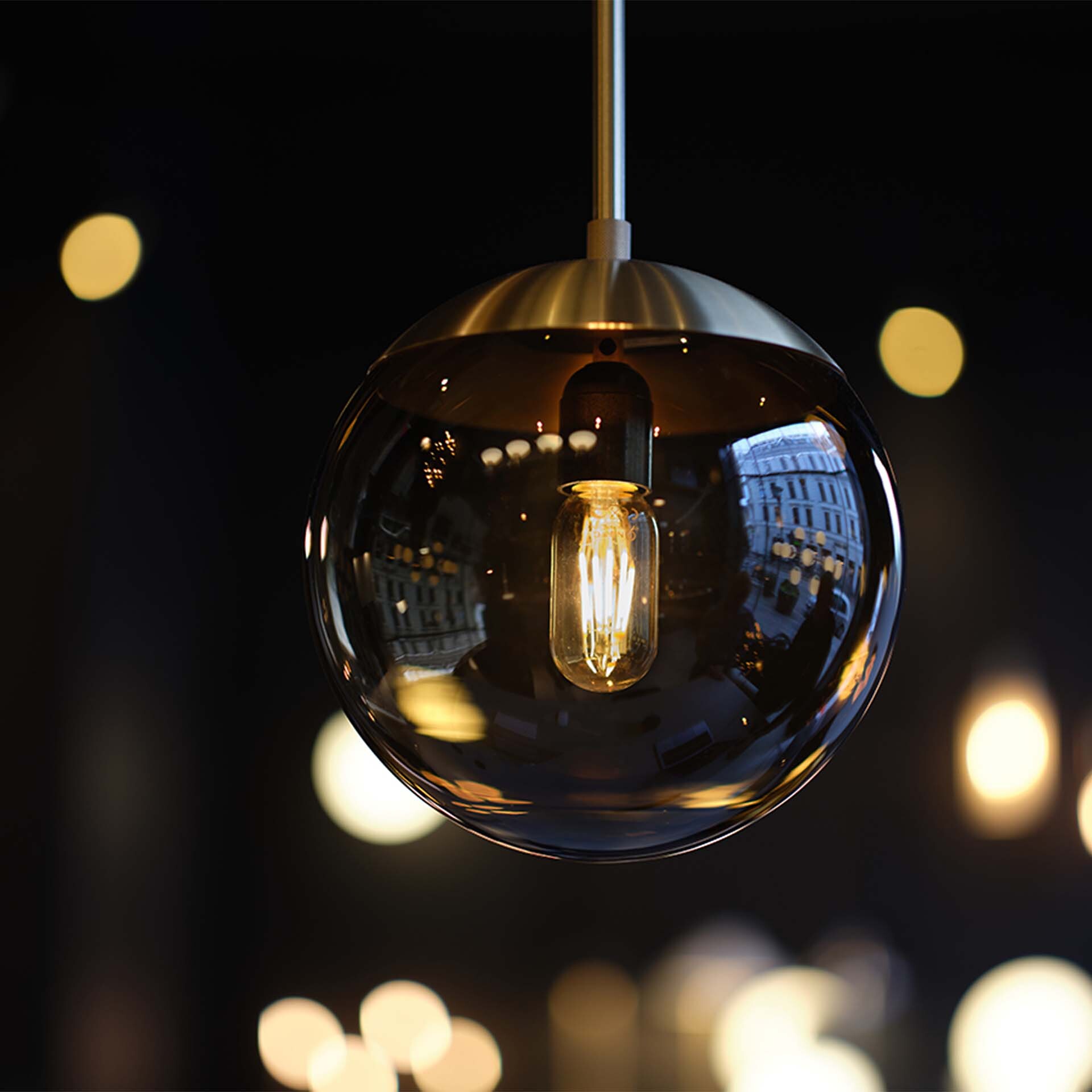 Pendelleuchte Lord Pendant im Detail bei Nacht mit kleinen Lichtern im Hintergrund