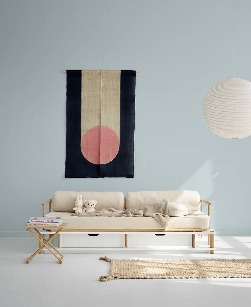 Hellbeiges Kindersofa von Oliver Furniture vor hellblauer Wand mit Wanddeko und Teppich  