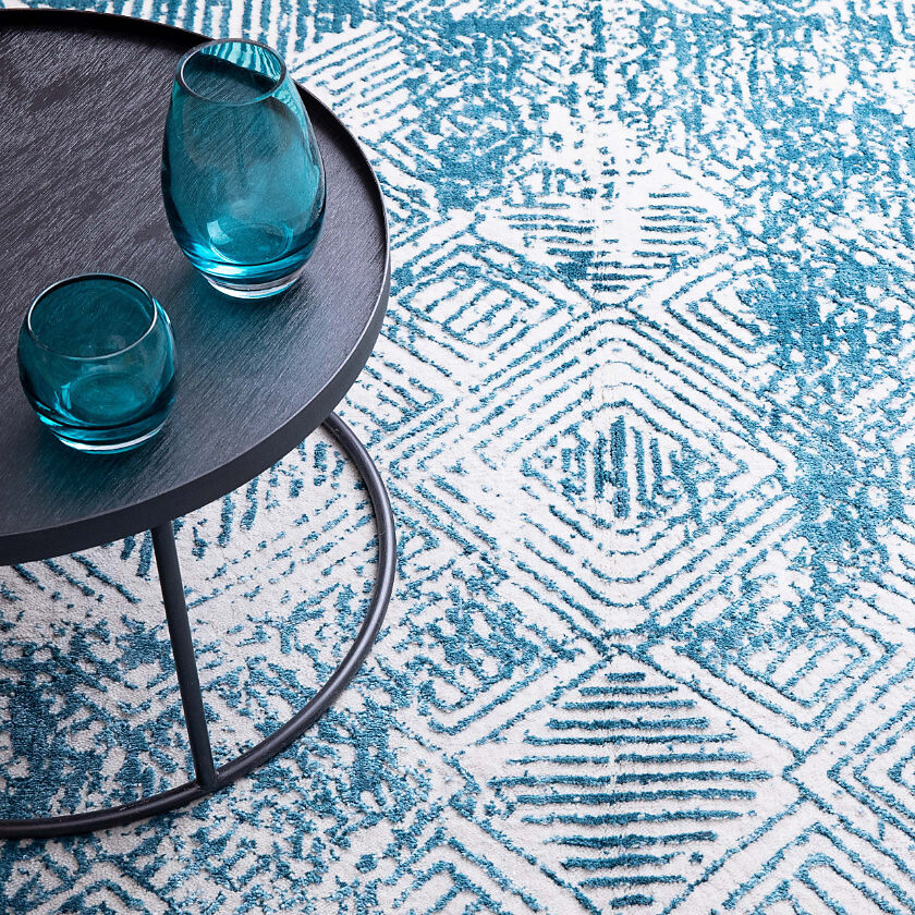 Nahaufnahme eines Teppichs mit türkis-weißem Rautenmuster