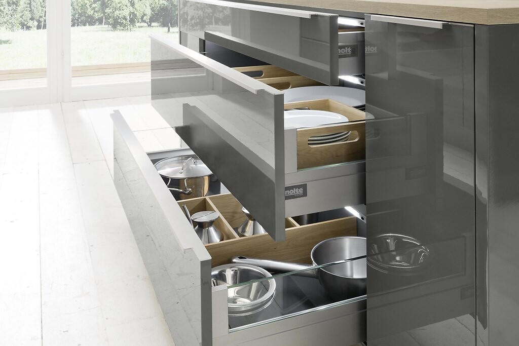 Geöffnete Schubladen einer Nolte Küche mit Töpfen, Pfannen und Besteckeinsätzen