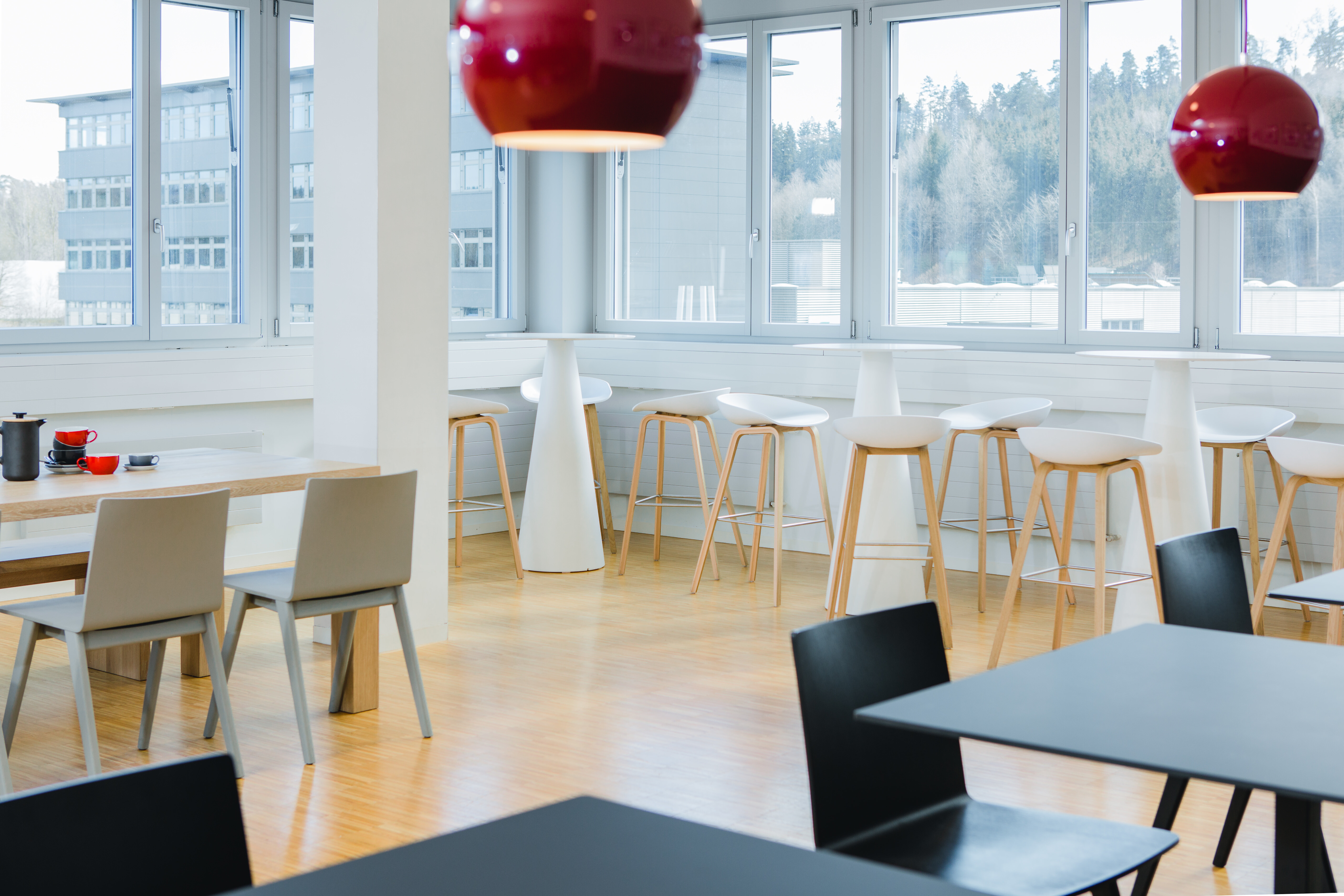 Der große Gemeinschaftstisch wird ergänzt durch Bistrotisch, sowie runde Stehtisch und passenden Barhockern About a Stool.