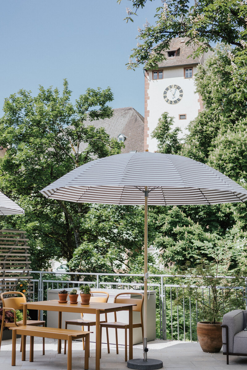 Dachterrasse der Ausstellung in Waldshut mit moderner Outdoor-Möblierung und Ausblick auf das historische Schaffhauser Tor im Hintergrund