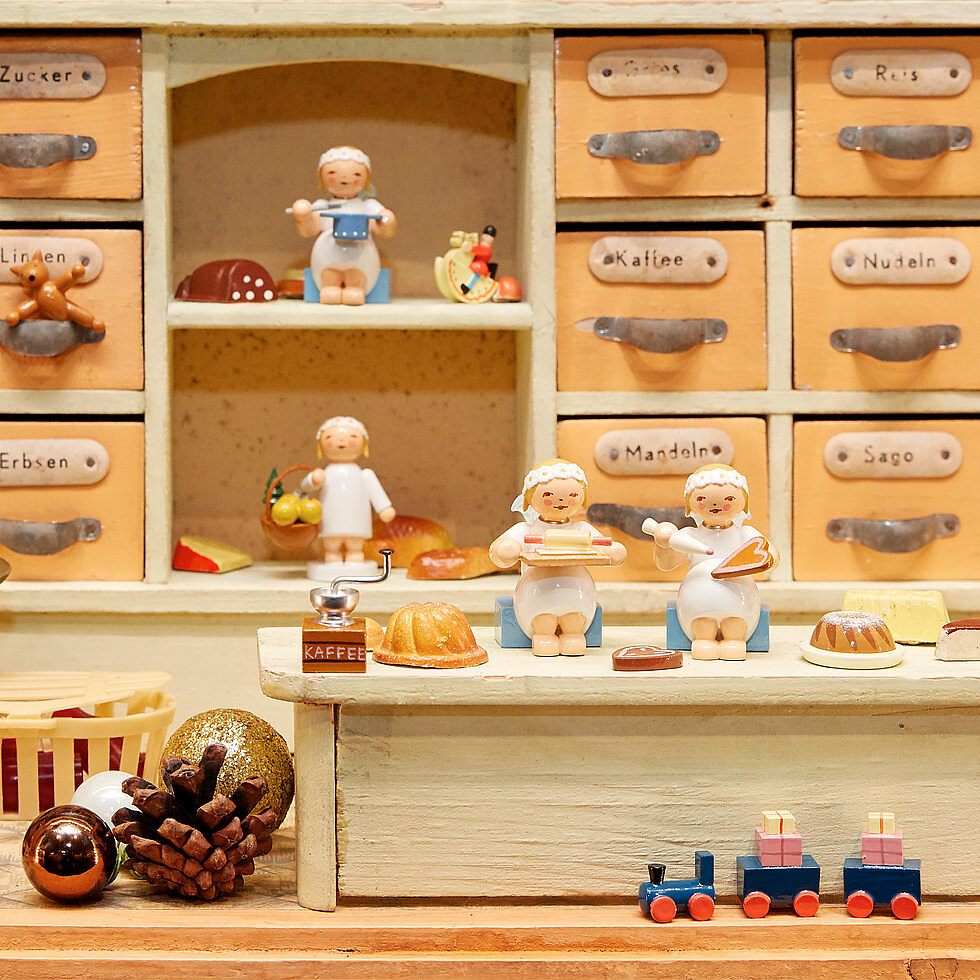 Margeritenengel im Kaufmannsladen beim Kochen und Backen