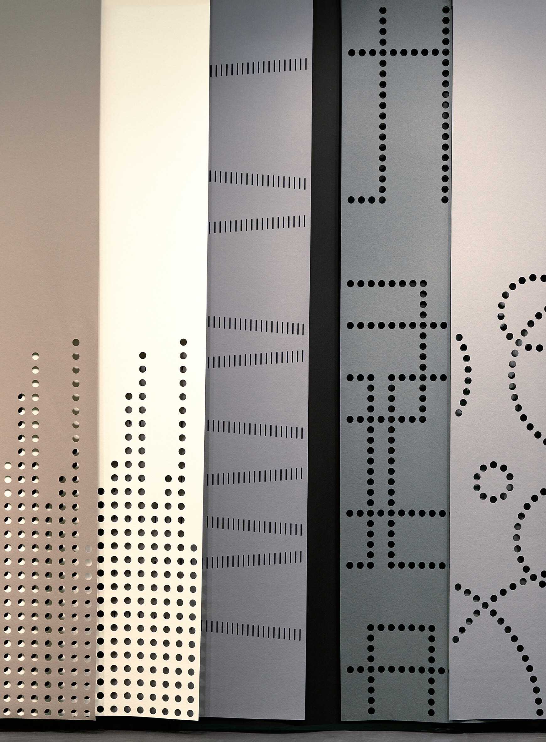 Akustikpaneele mit grafischen Mustern aus punktuellen und linearen Perforationen