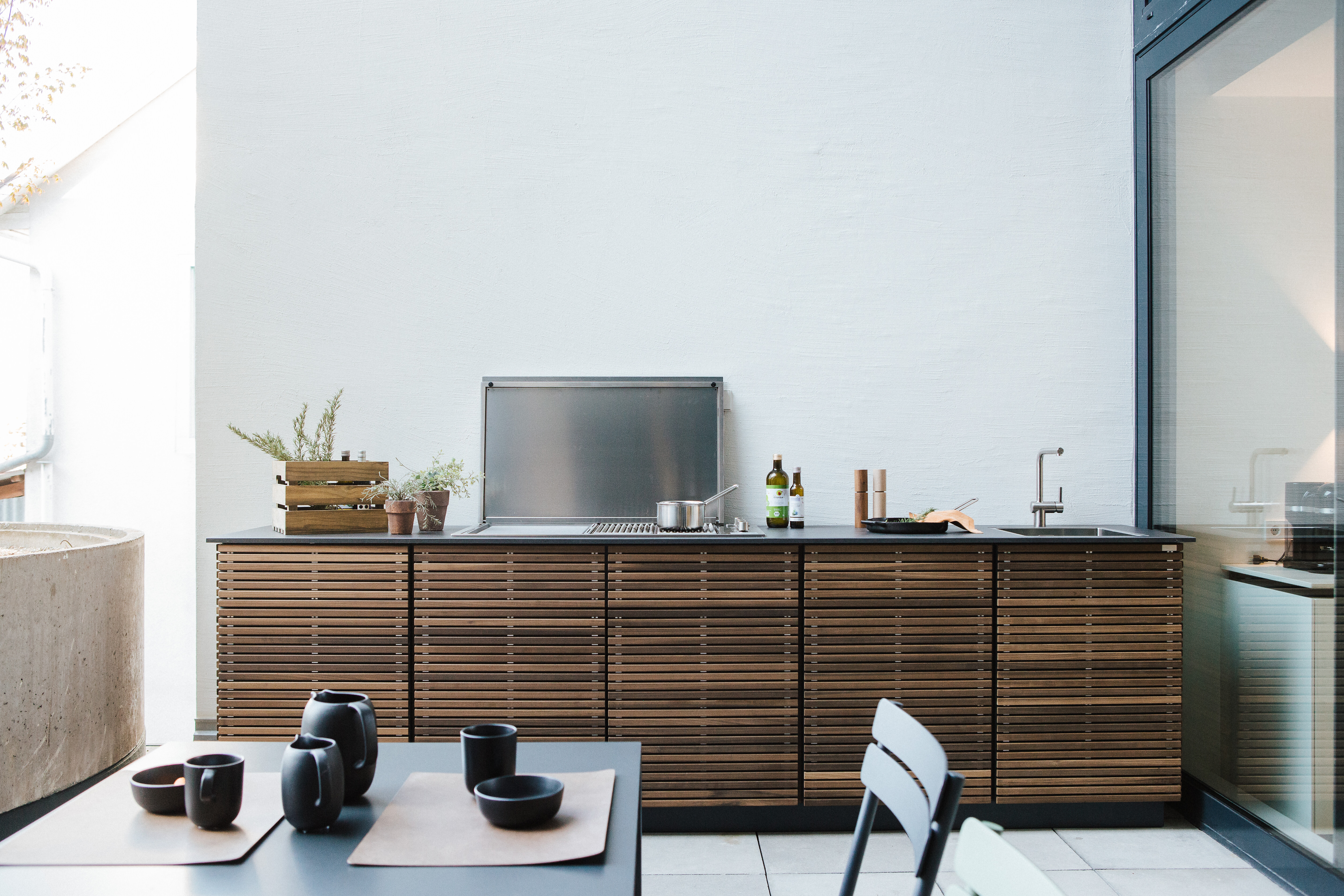 Cubic Outdoor-Küche auf Terrasse bei Seipp Wohnen mit Esstisch, Stühlen und Grillfläche  