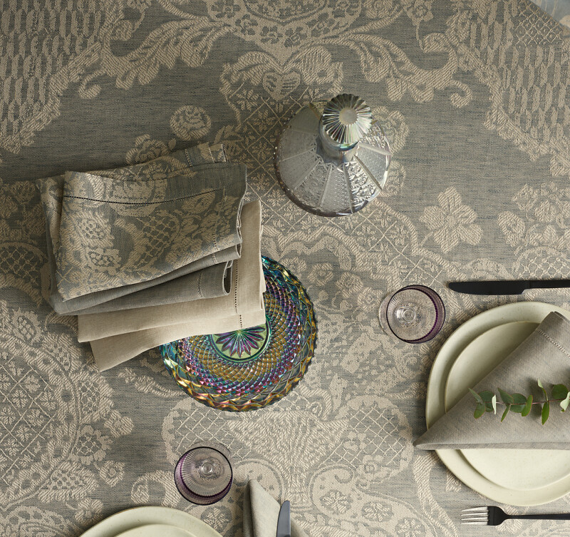 Strukturreiche Tischdecke mit Stoffservietten und Porzellanteller