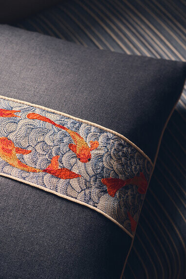 Dekoratives Kissen mit bestickter Borte und Fischmotiv