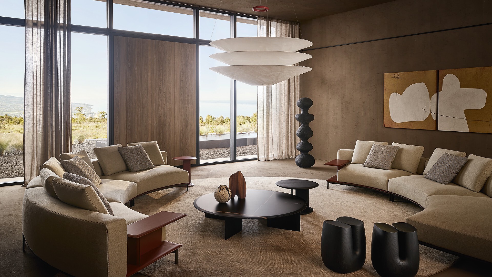 Großer Wohnraum mit runden Poliform-Sofas, niedrigen Tischen und hoher Fensterfront