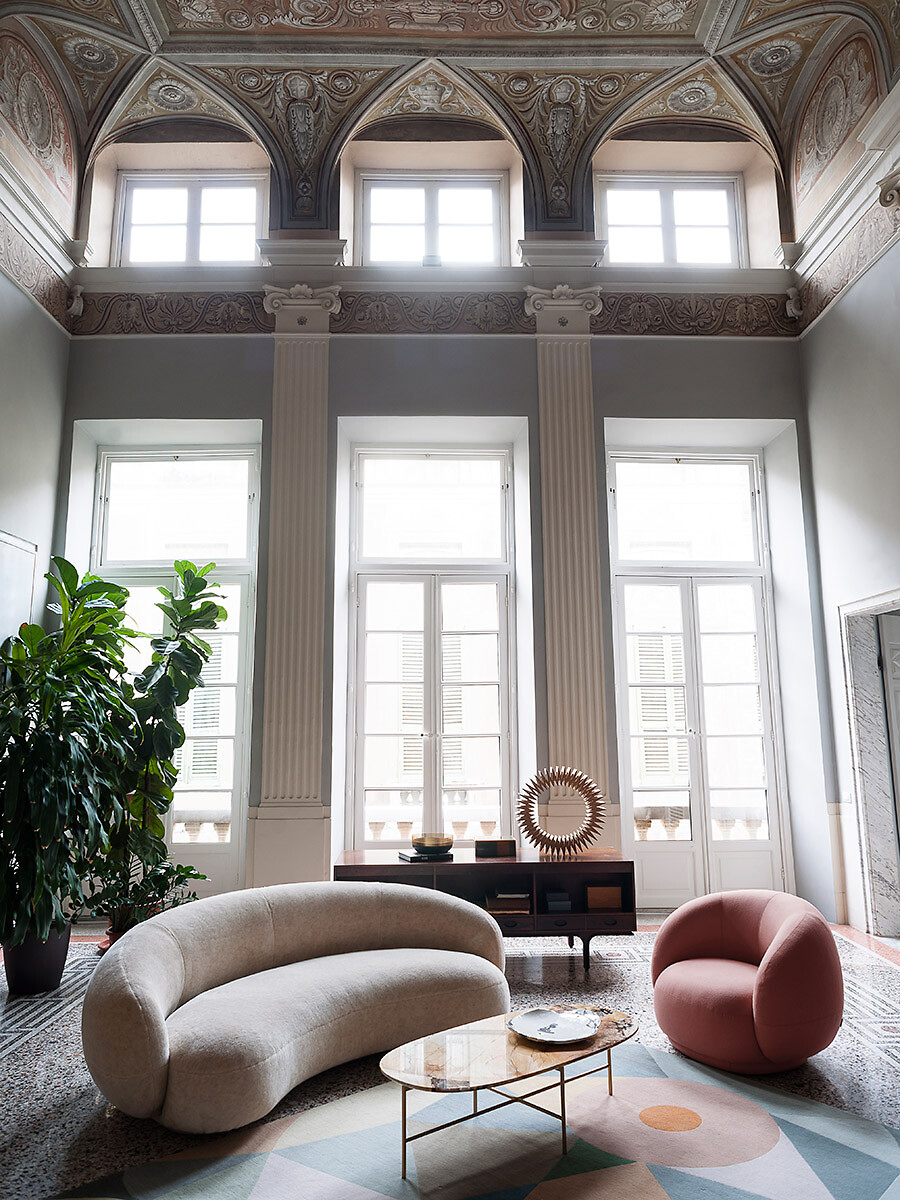 Weiches Sofa mit passendem Sessel vor hoher Fensterfront