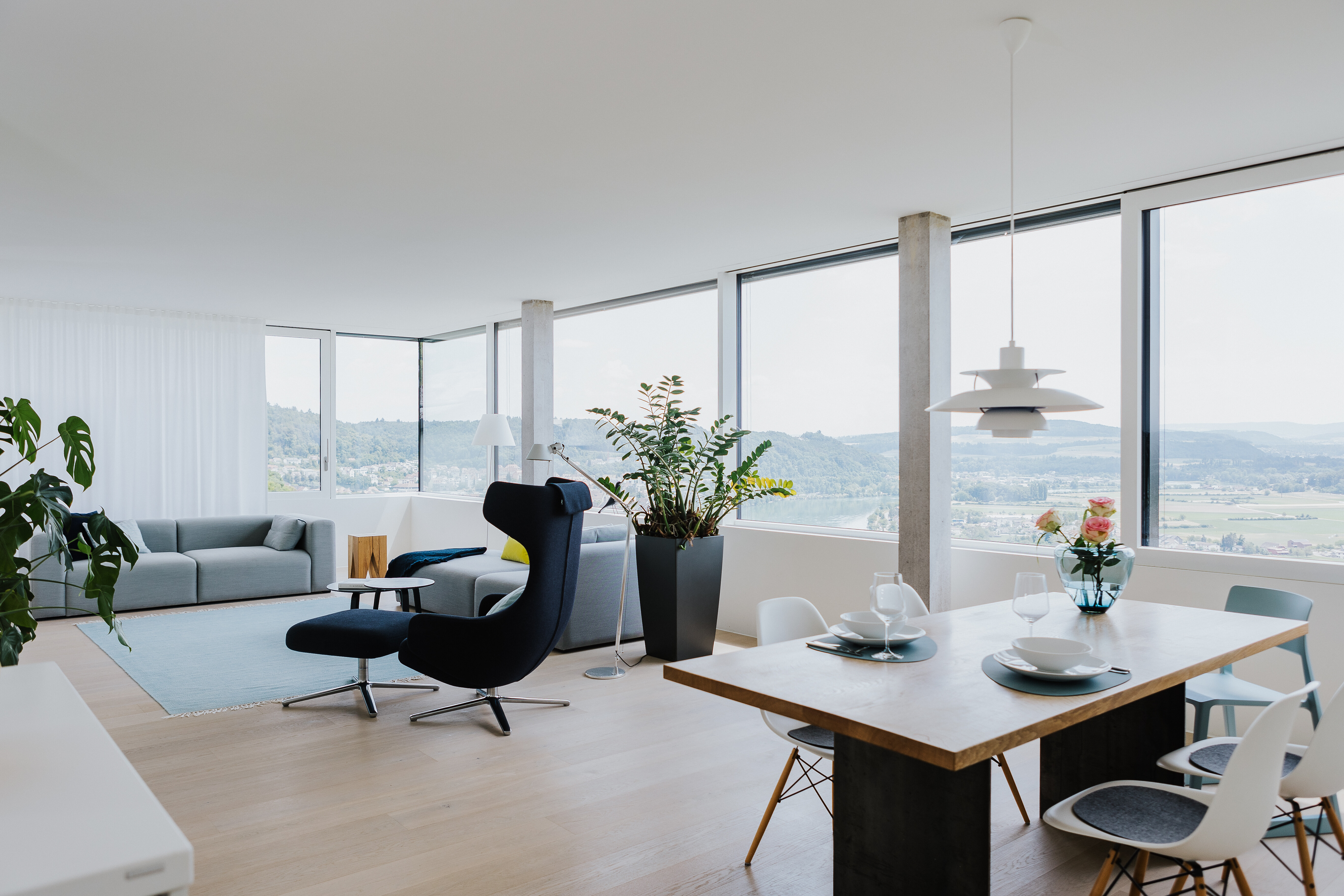 Wohnbereich mit Designklassikern, Pastellfarben und Panoramablick – stilvoll und lichtdurchflutet