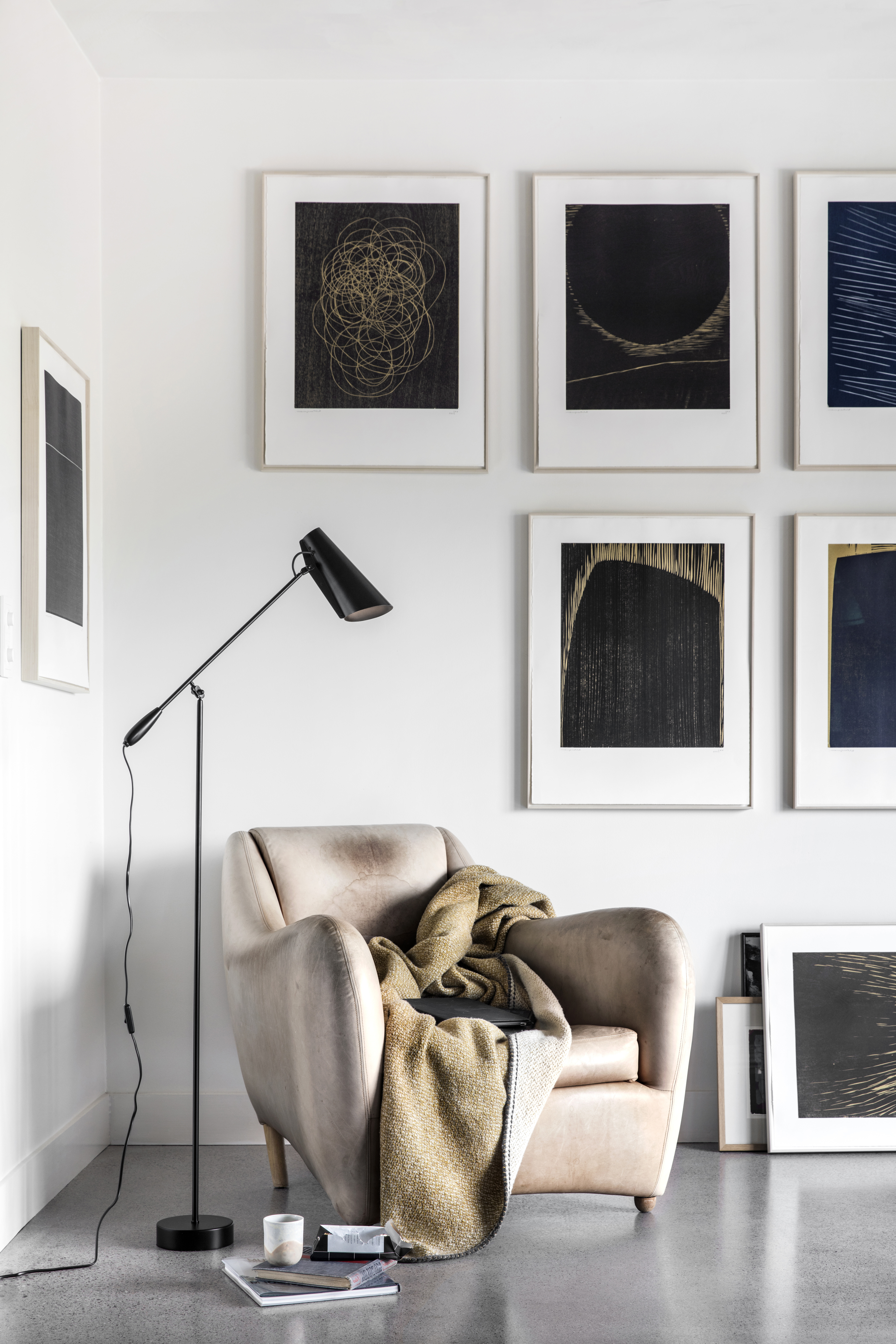 Birdy Stehleuchte von Northern neben Sessel und gerahmten Grafiken an weißer Wand  