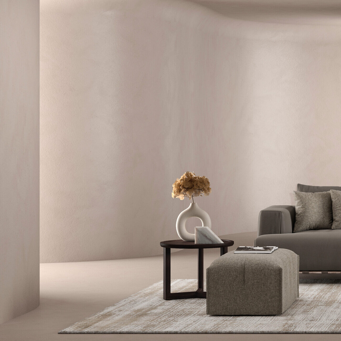 Graues Sofa mit rechteckigem Pouf, rundem Beistelltisch und Vase auf hellem Teppich  