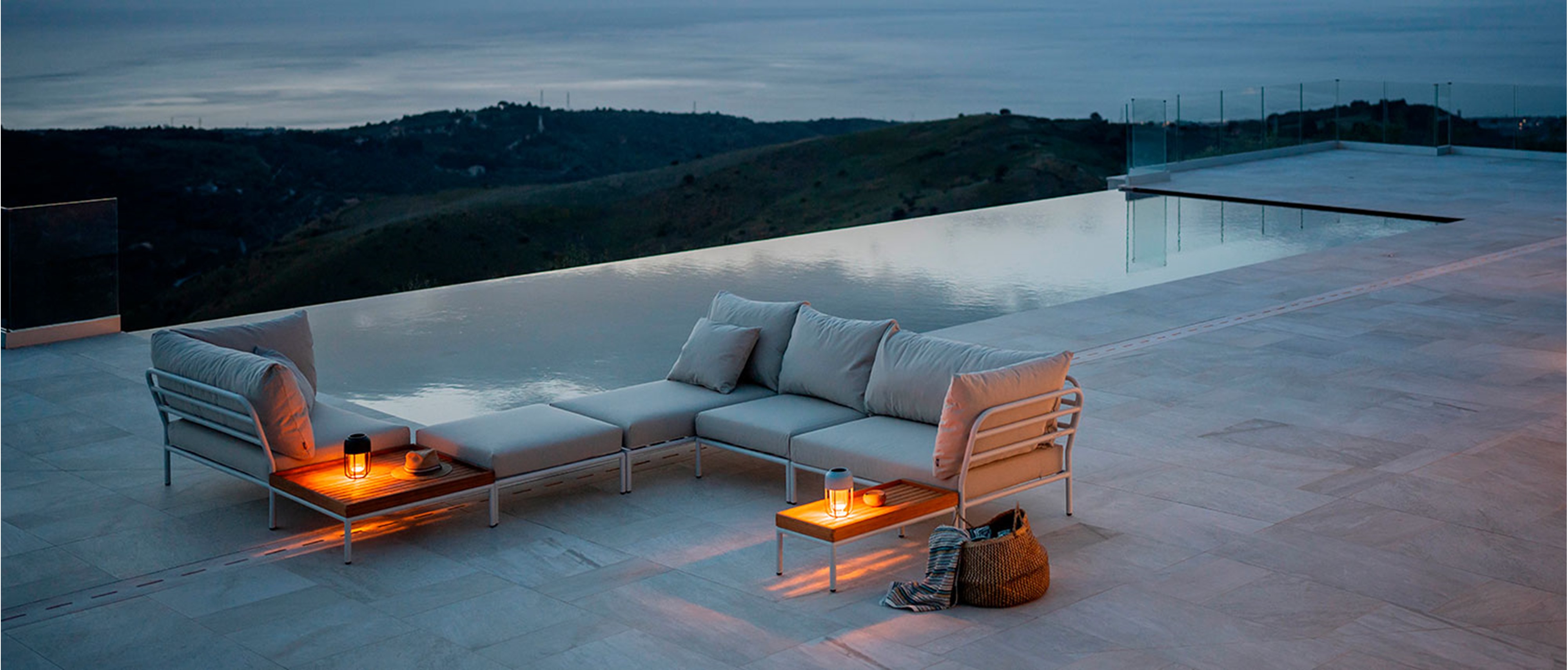 Zwei Solarleuchten Light No1 von Houe stehen auf den integrierten Ablagen eines Outdoor-Sofas