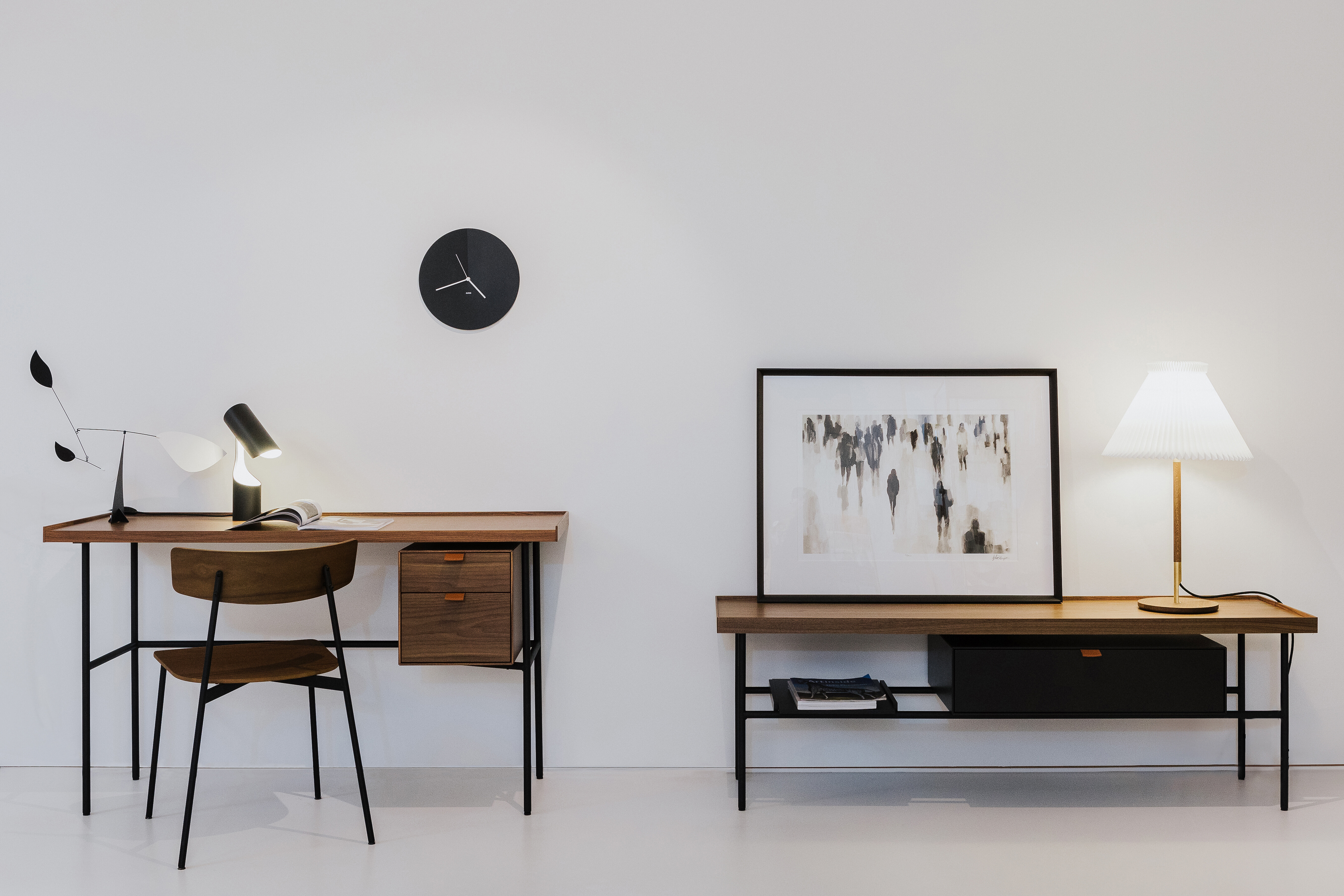 Wohnlicher Arbeitsplatz mit Schreibtisch und Sideboard aus Holz, Leuchten und Wandobjekten