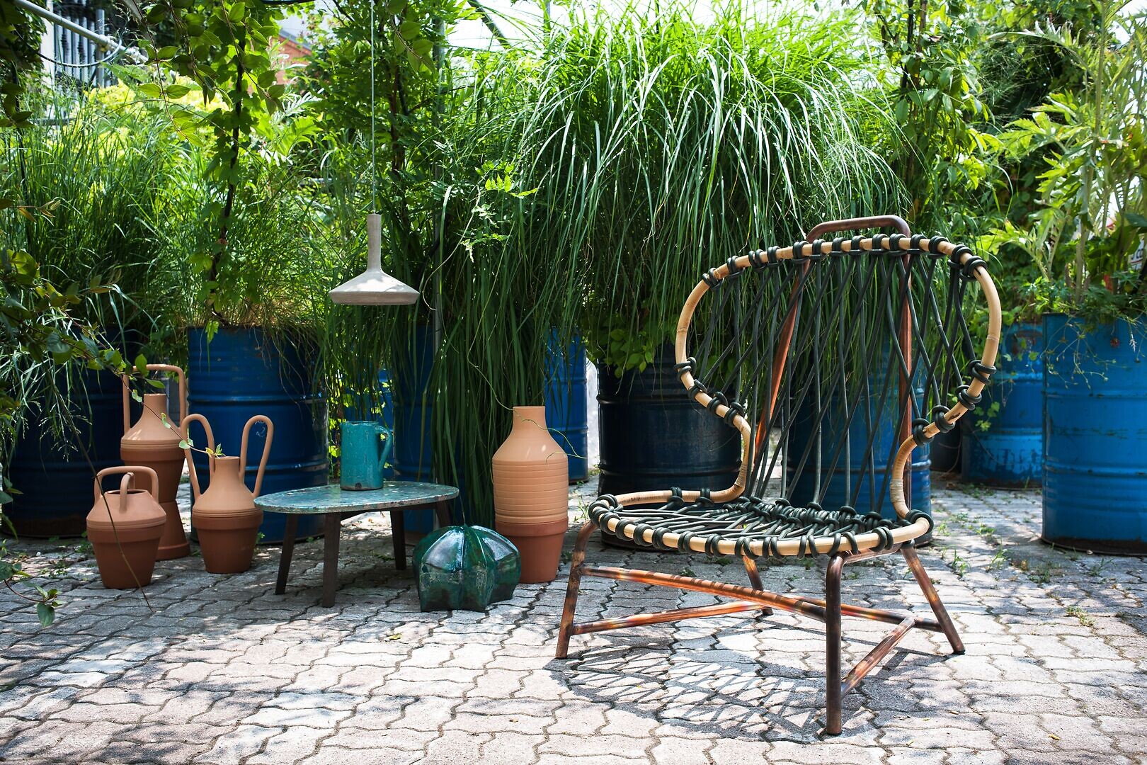 Geflochtener Outdoor-Sessel aus Metall und Seil auf gepflastertem Boden