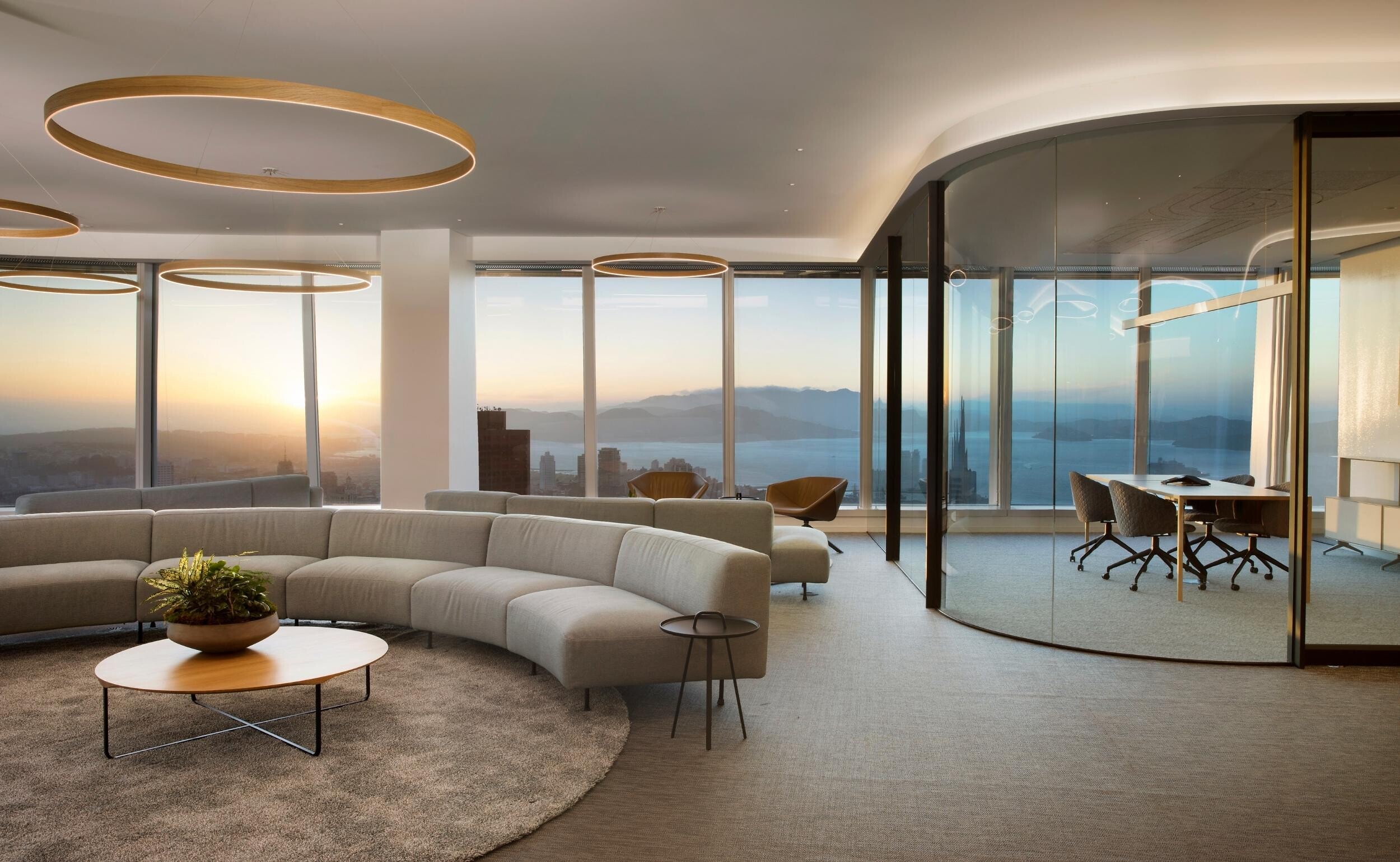 Großer runder Teppich in heller Strukturfarbe unter halbkreisförmigem Sofa und Couchtisch