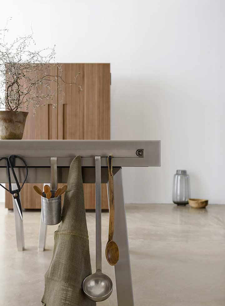 bulthaup Werkbank mit Küchenutensilien im Vordergrund, Werkschrank aus Holz im Hintergrund