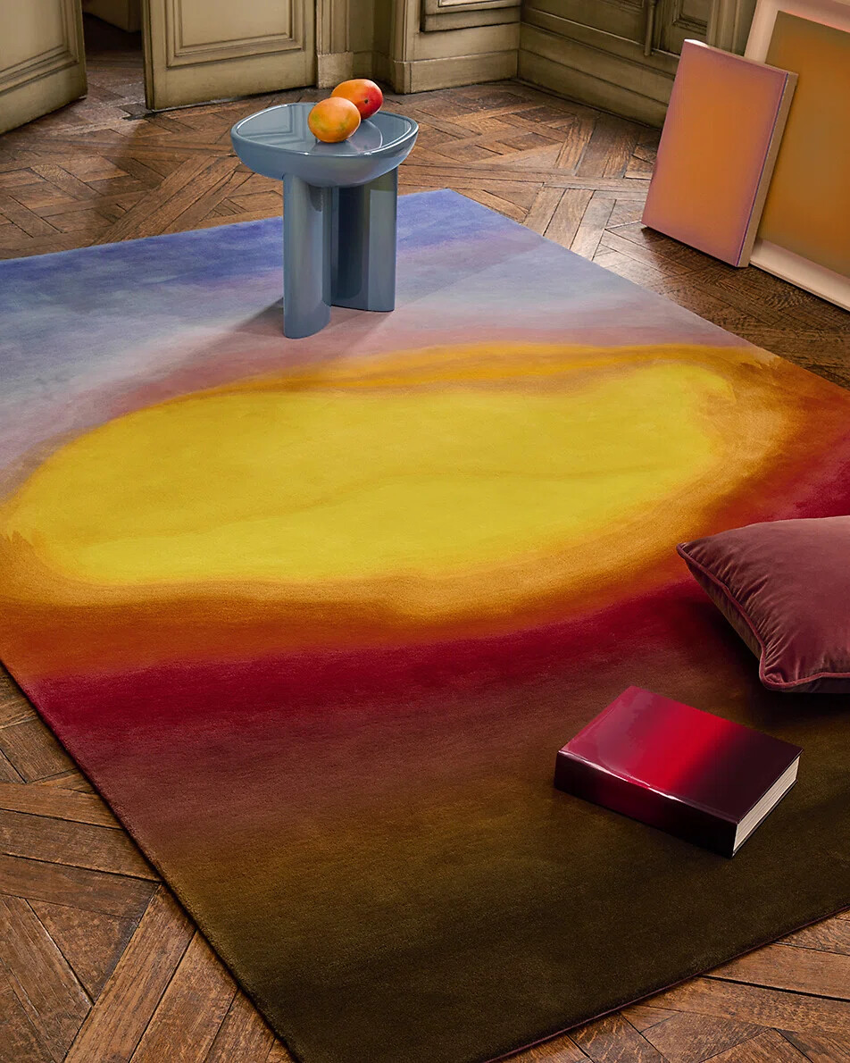Teppich mit dynamischem Farbverlauf in Gelb, Rot und Violett auf Parkettboden  