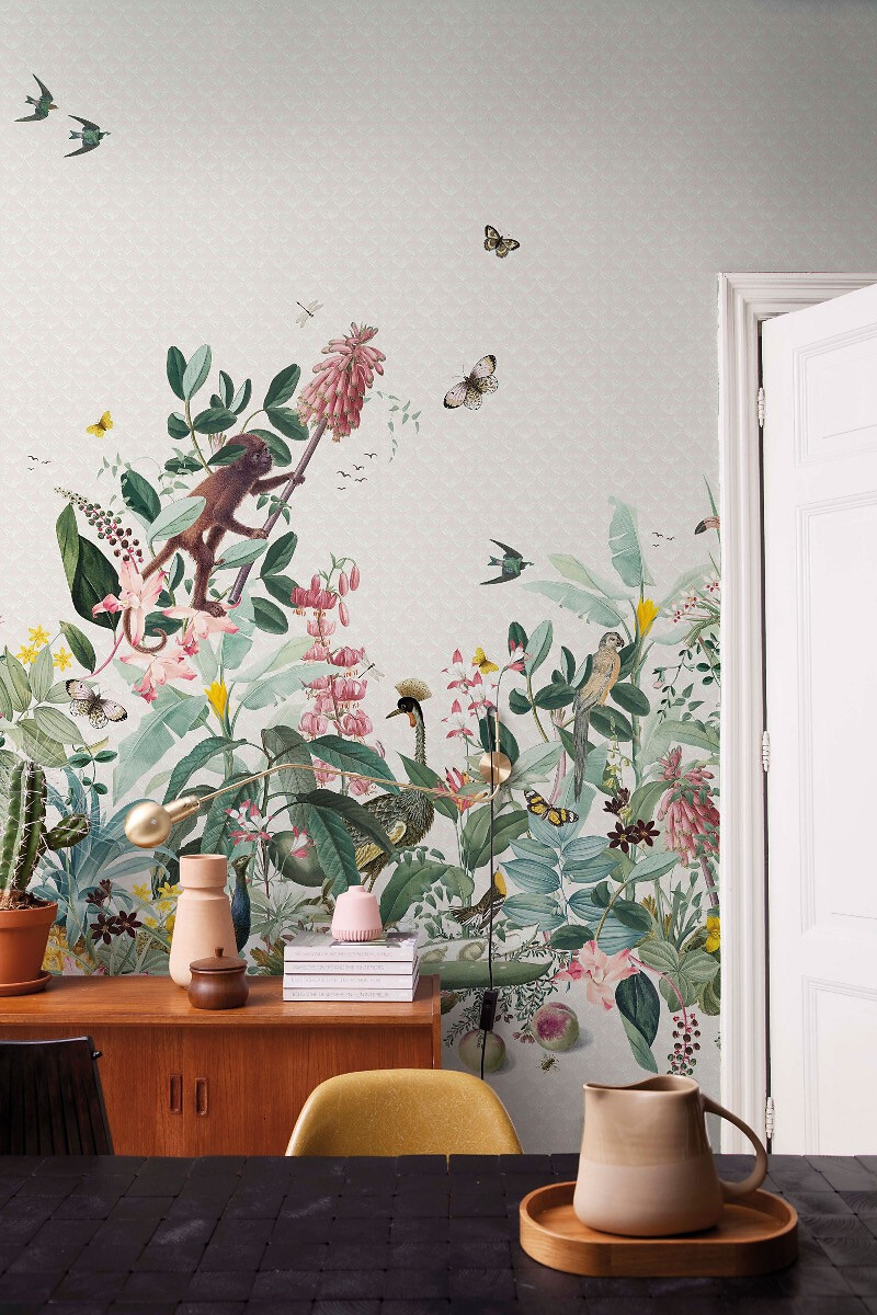 Helle Tapete mit botanischen Illustrationen und Tieren hinter Sideboard und Deko  
