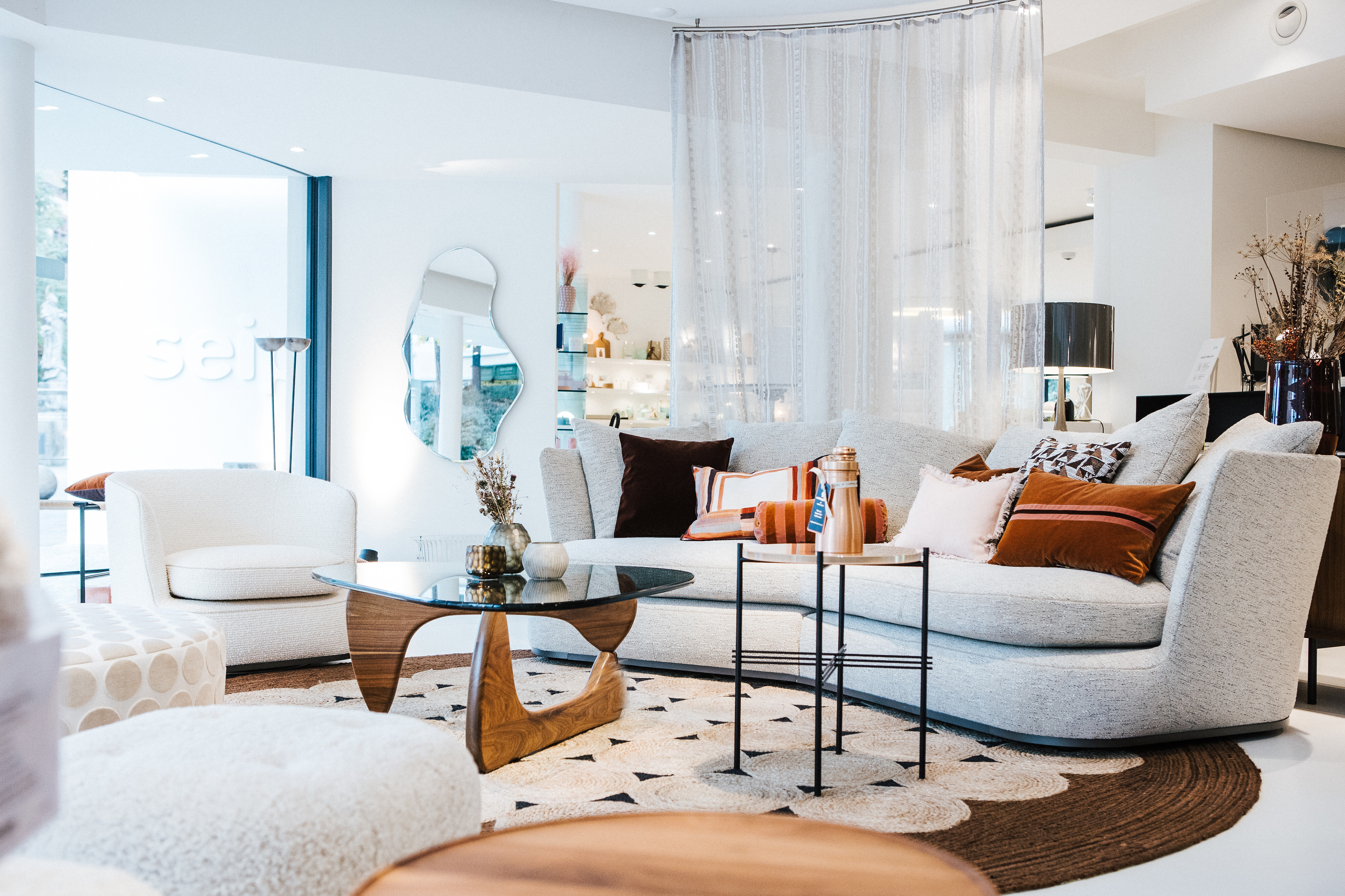 Wohnbereich mit rundem Sofa, textiler Raumtrennung und Coffee Table von Vitra in organischer Form