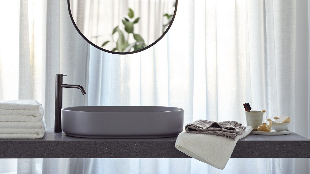 Badtextilien von Luiz neben Waschbecken auf Ablage mit Spiegel