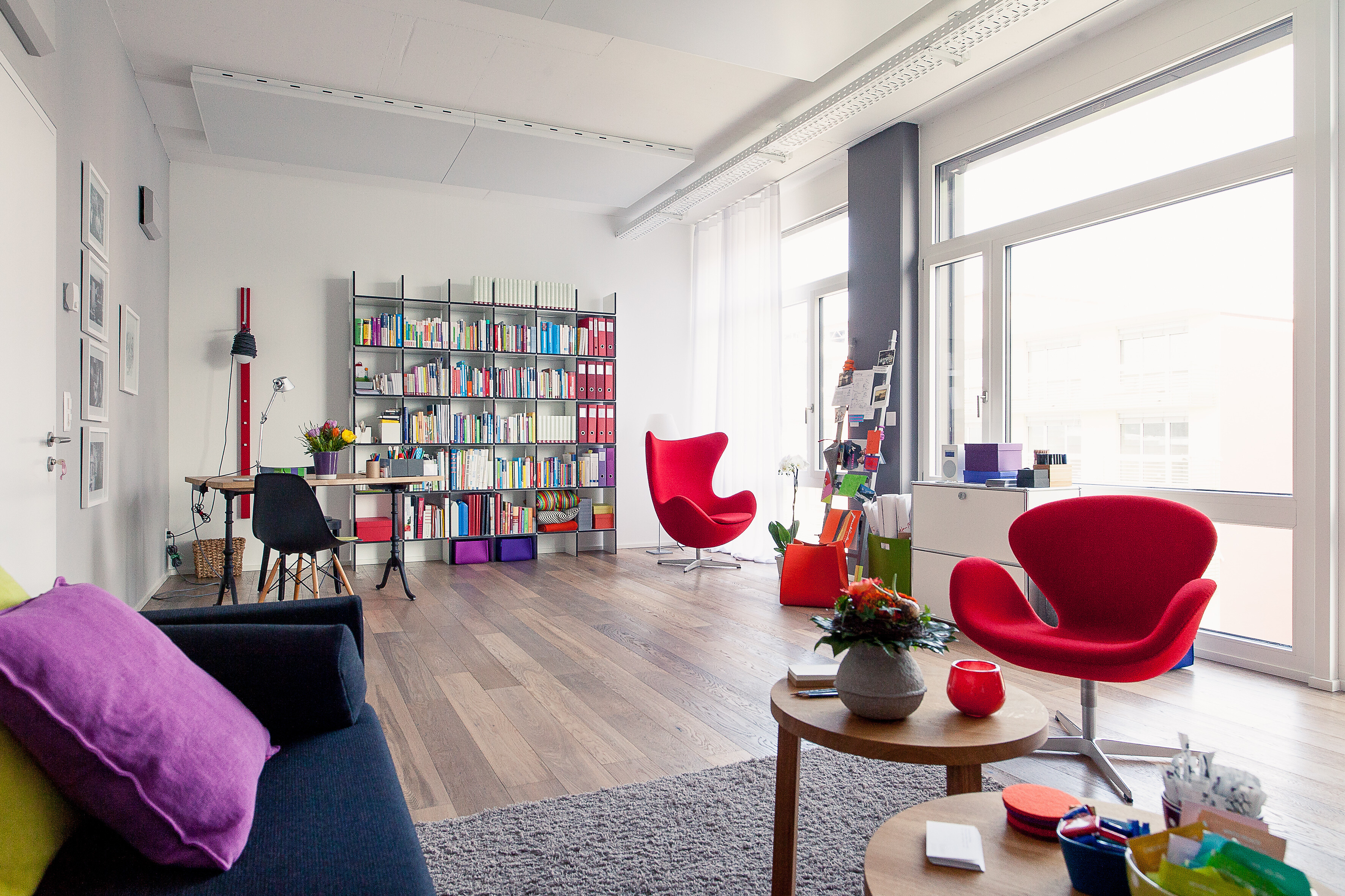 Der Mensch im Zentrum Die Einrichtung der Unternehmensräume erfolgte unter Kriterien, die Wohlfühlen und Strahlkraft erzeugen. Moderne Klassiker in bunten Farben, klassisches Schwarz-Weiß und die Wärme von Holz harmonieren hier bestens miteinander.