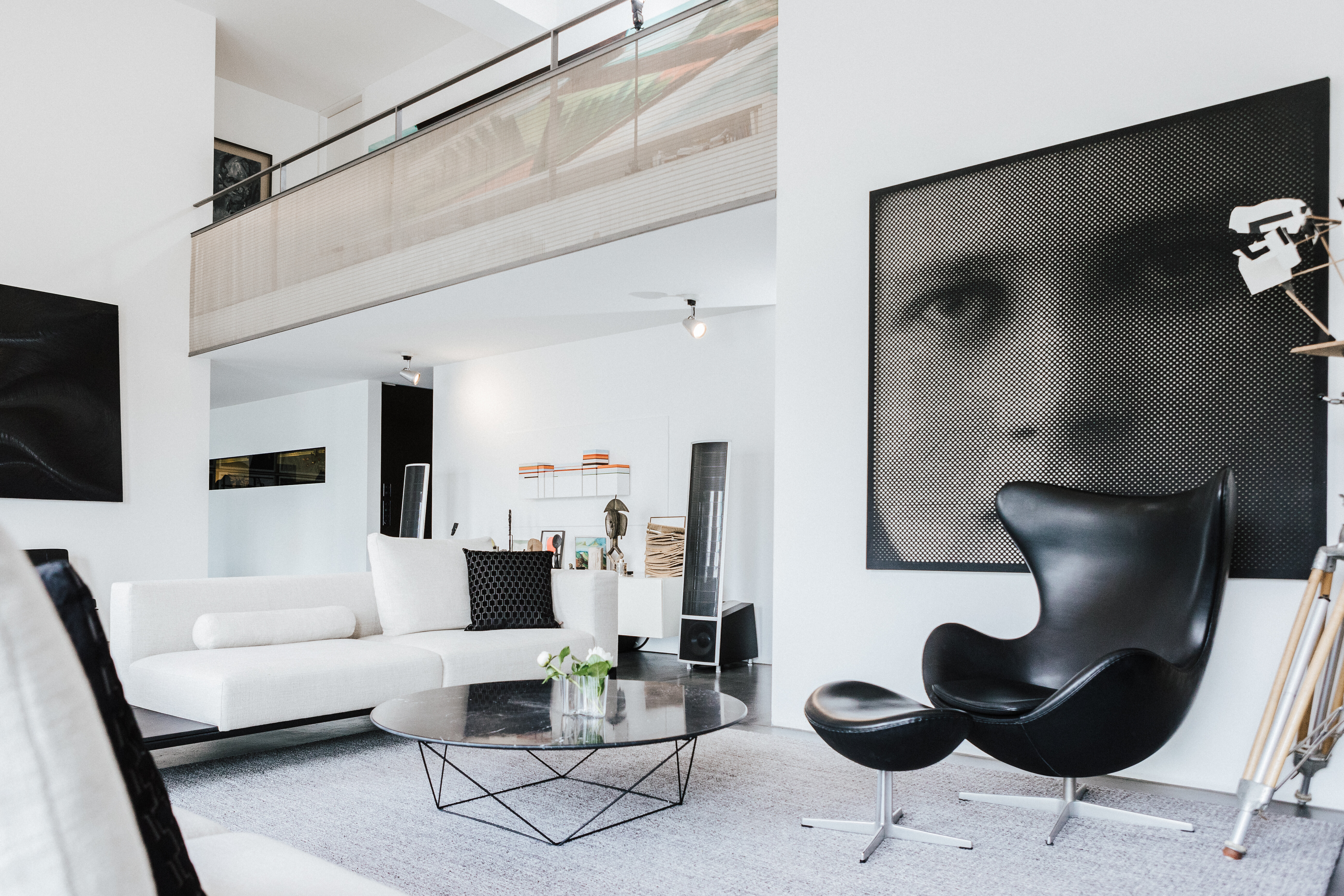 Modernes Wohnzimmer mit weißem Sofa, Egg Chair von Arne Jacobsen und großformatigem Porträtbild