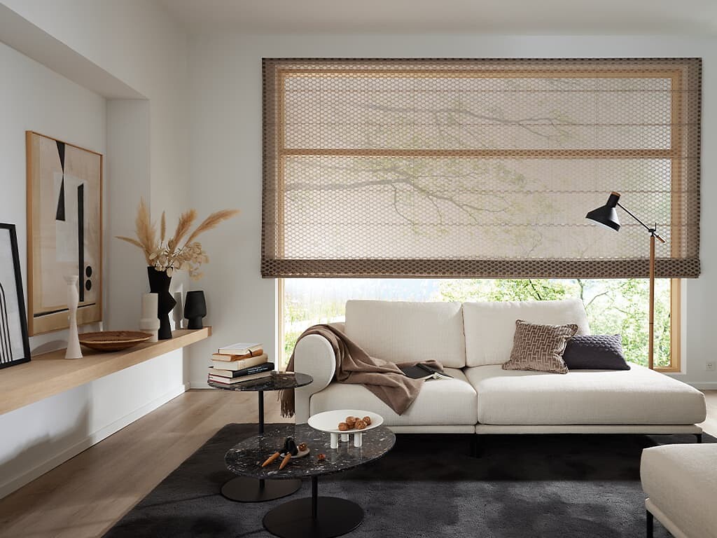 Raffrollo mit feiner Struktur vor großem Fenster in hellem, modernem Wohnzimmer  