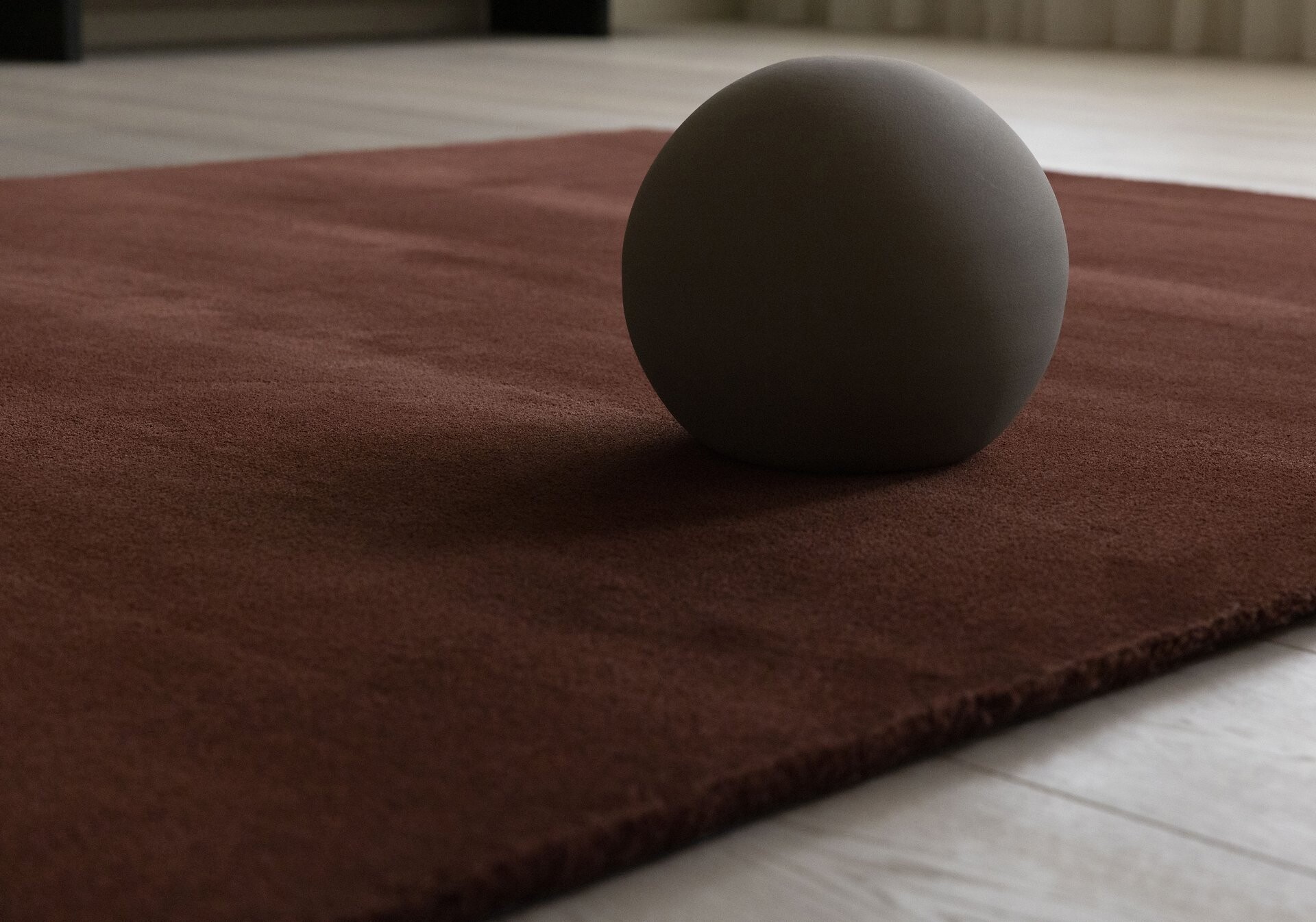 Roter Teppich in minimalistischem Raum mit Kugelobjekt auf hellem Holzboden  