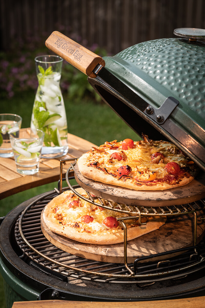 Zwei Pizzen auf Pizzasteinen im EGGspander-System des Big Green Egg Grills mit offenem Deckel  