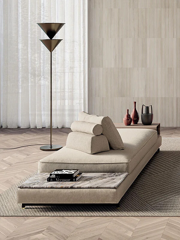 Beiges Sofa Davis mit Nackenrolle auf Holzfußboden vor heller Lamellenwand