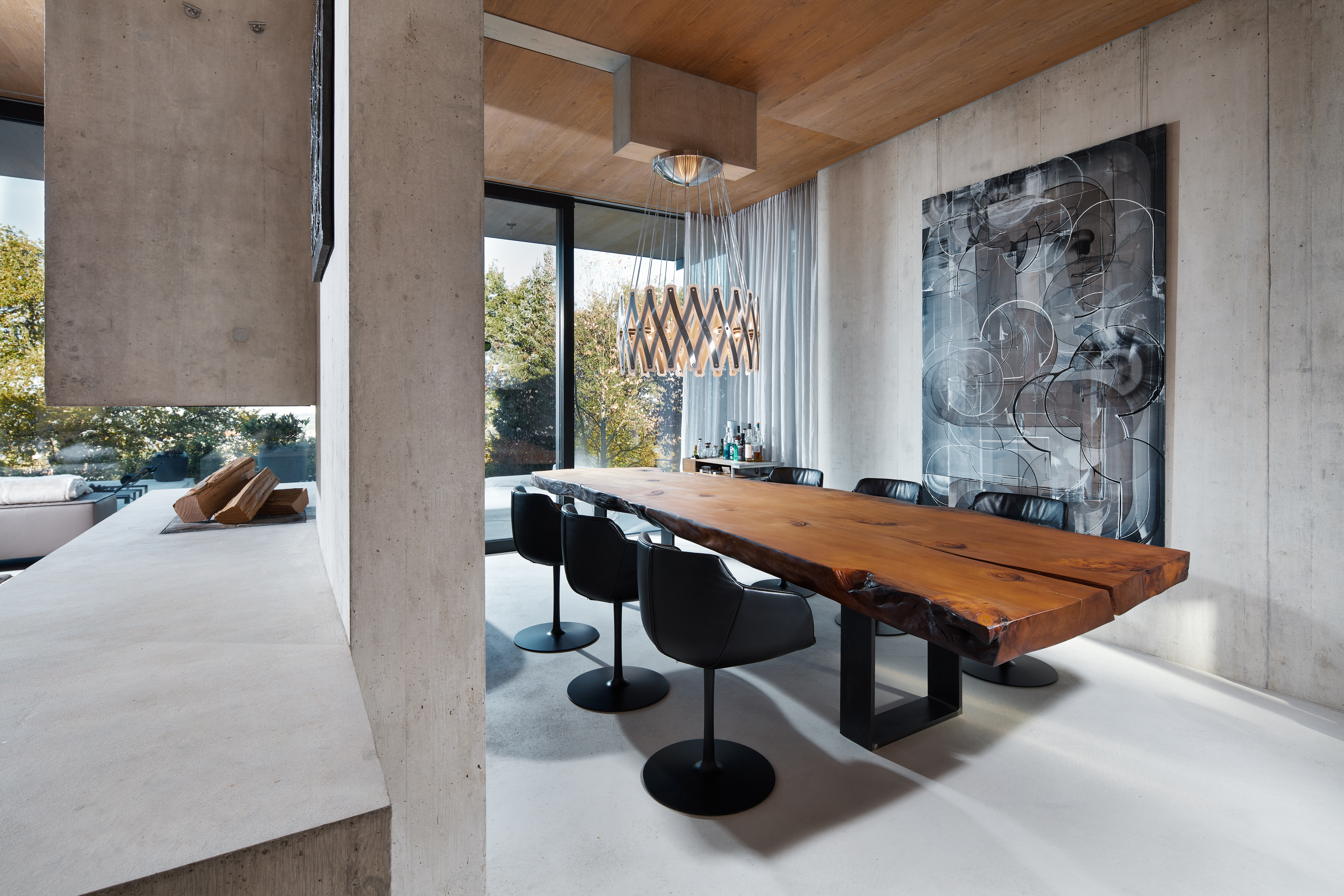 Beton, Holz und Glas bilden die Basis des modernen Neubaus. Mittelpunkt ist das offen gestaltete Erdgeschoss mit Wohn-, Koch- und Essbereich. Eine Besonderheit ist bereits von außen gut ersichtlich – das verbindende Element Eichenholz. Im Erdgeschoss zier