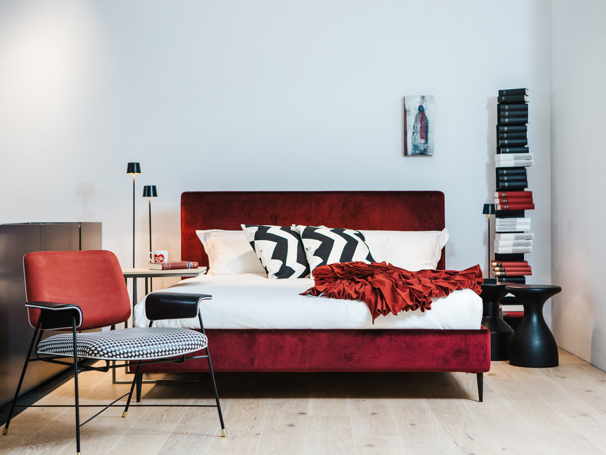 Bett mit rotem Samtbezug in der Ausstellung 2025 bei Seipp Wohnen Tiengen, ergänzt durch Sessel