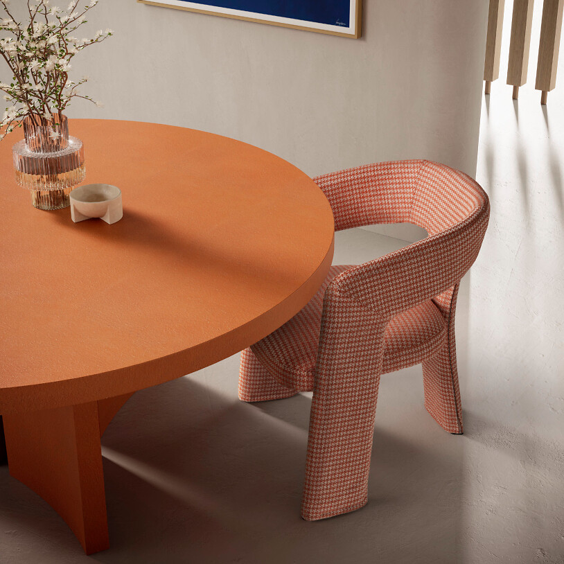 Runder orangefarbener Esstisch mit gepolstertem Stuhl im Karomuster in Rosatönen  