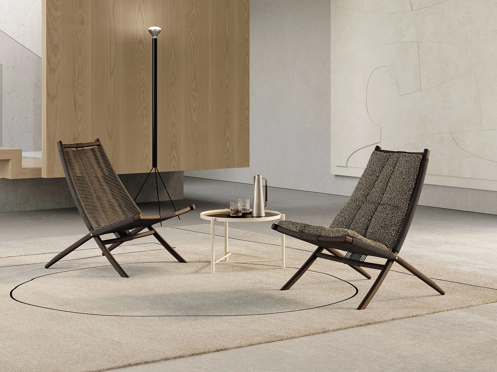 Zwei Sitzmöbel Huli mit dunkler Polsterung und Holzrahmen auf Teppichinsel