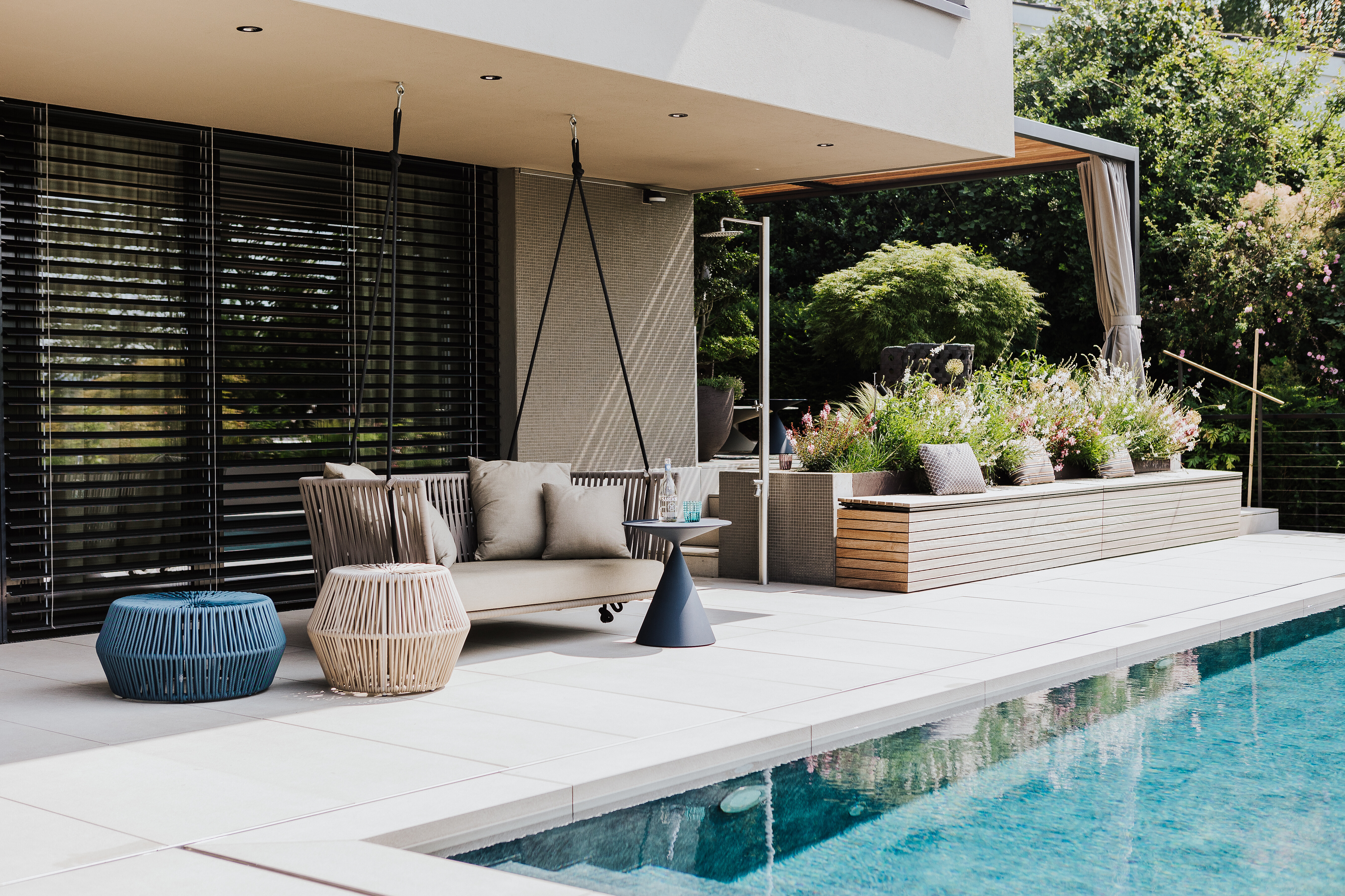 Terrasse mit Pool, Schaukelbank und Beistelltischen – modernes Einrichtungskonzept von Seipp Wohnen  