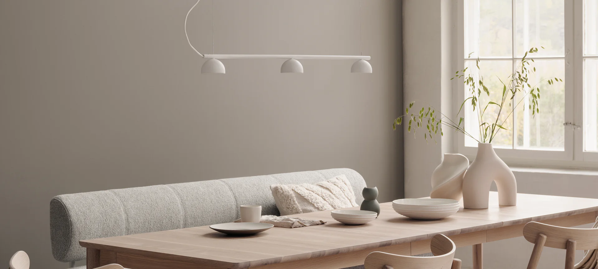 Pendelleuchte mit drei Schirmen von Northern über hellem Holztisch mit Keramikobjekten  