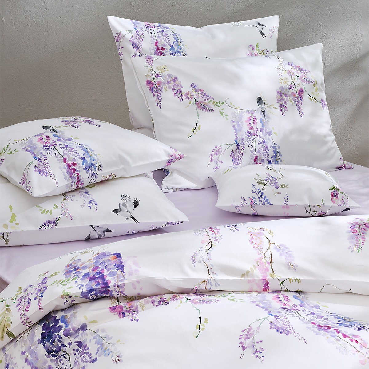 Nahaufnahme floral gemusterter Bettwäsche in Weiß- und Violetttönen