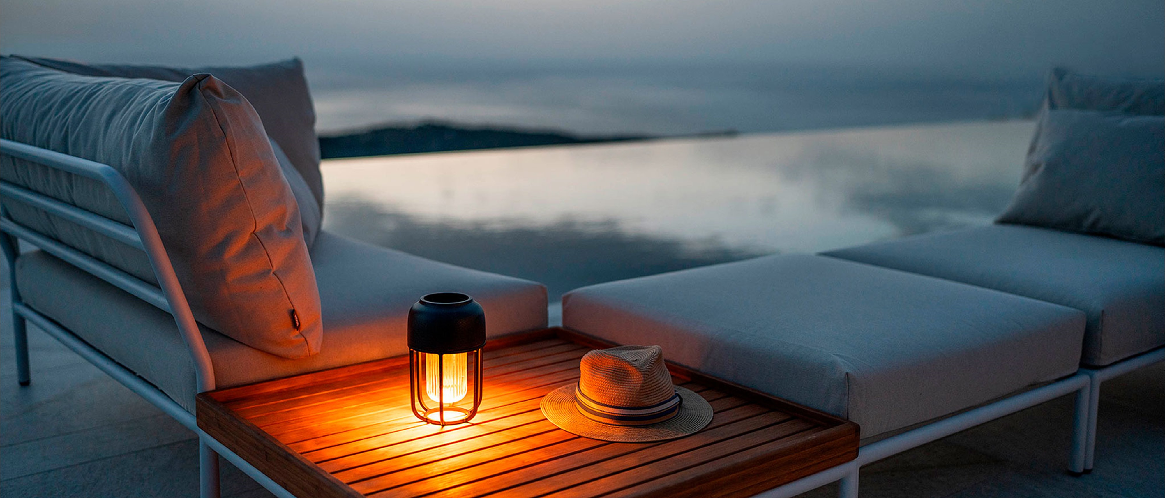 Die Solarleuchte Light No1 von Houe steht auf der Ablage eines Sofas