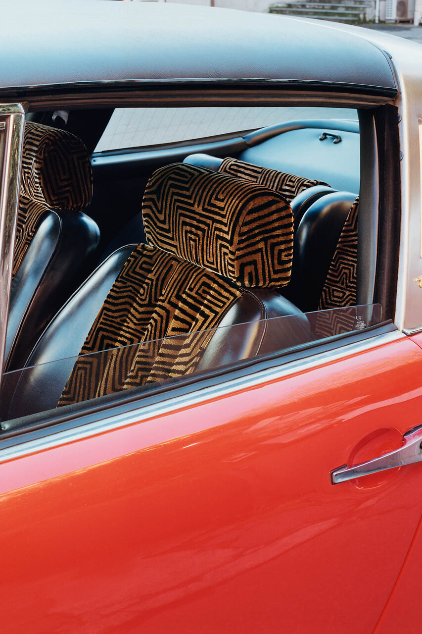 Sitzpolster eines Autos mit schwarzem Stoff und geometrischem Muster in Gold und Bronze