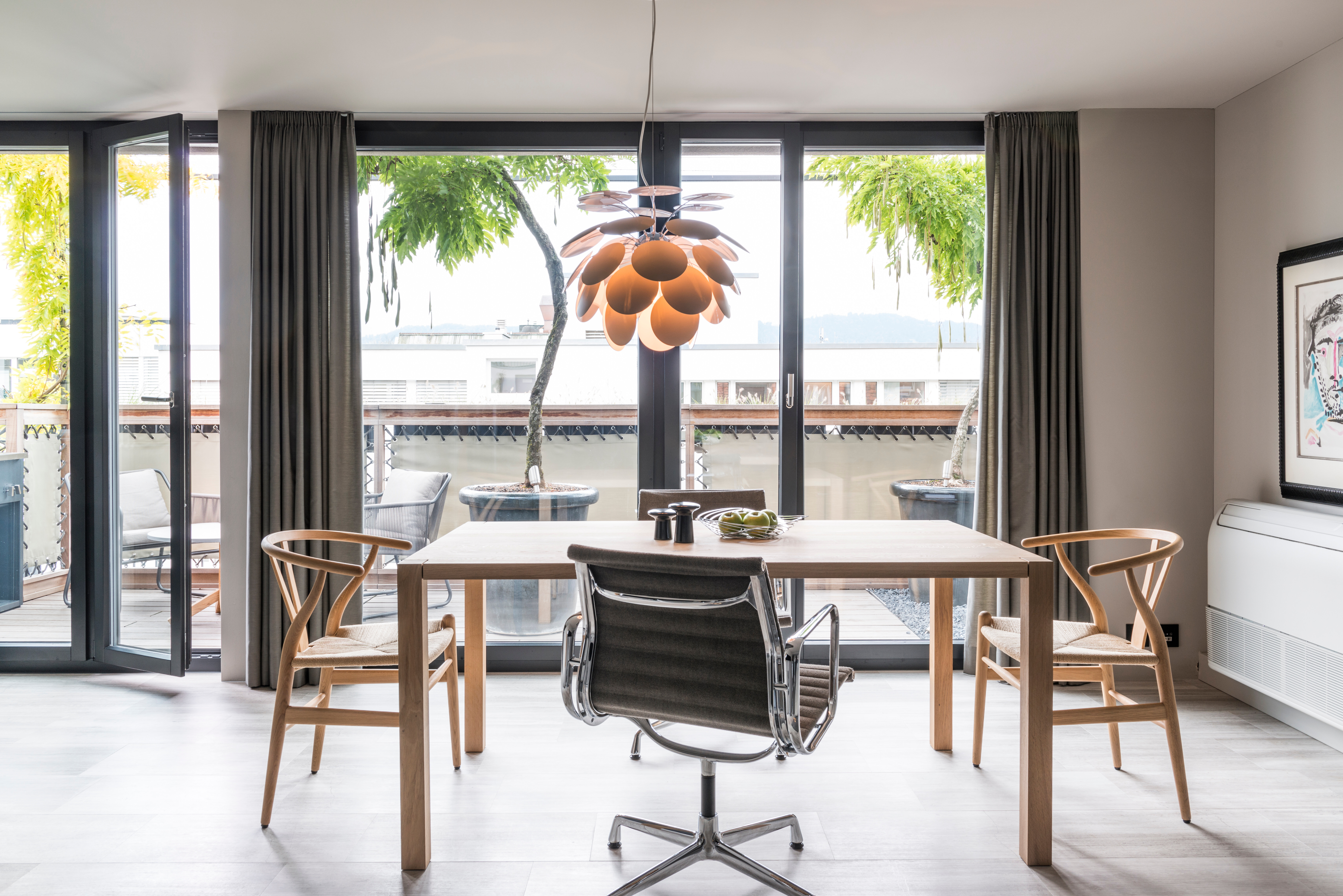 Esstisch Sloane von e15, Stuhl Y-Chair von Hans J. Wegner, Stuhl Aluminium Chair von Vitra, Design Ray & Charles Eames, Hängeleuchte Discoco von Marset.