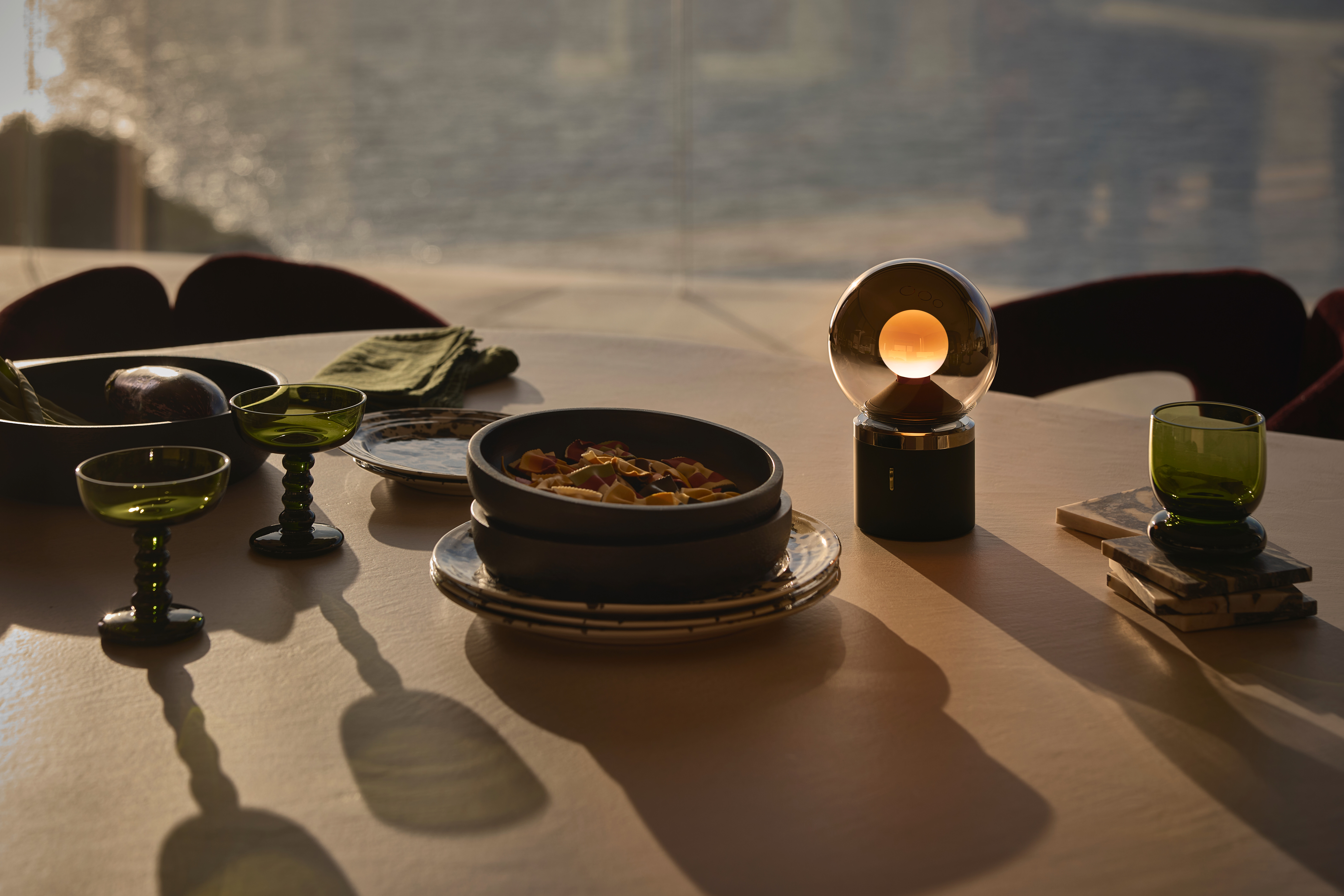 Tischszene mit Occhio Leuchte Luna pura, diffus leuchtend im abendlichen Außenbereich