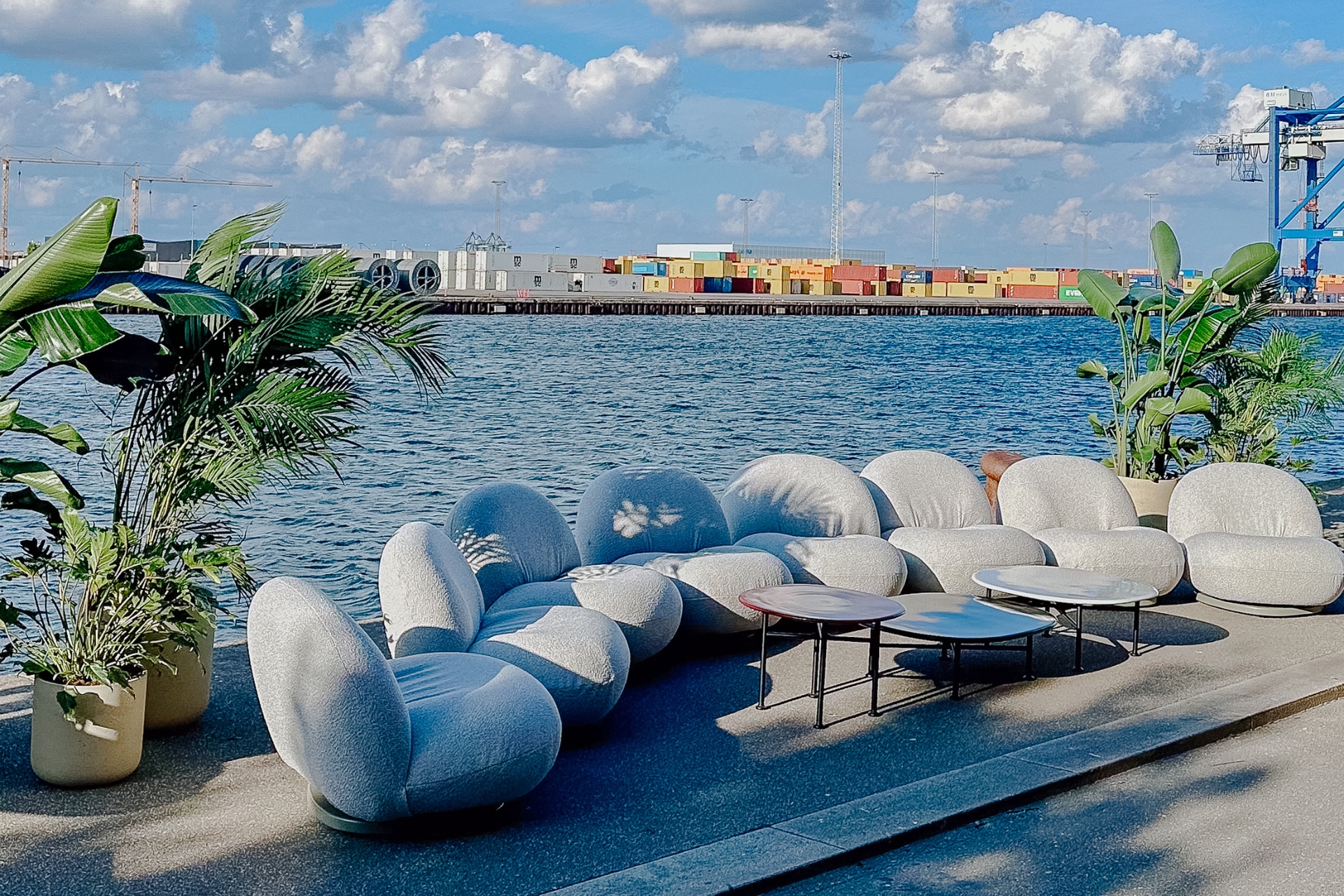 Outdoor-Sitzlandschaft mit hellen Modulen an der Hafenpromenade in Kopenhagen, Blick auf Container-Terminal.