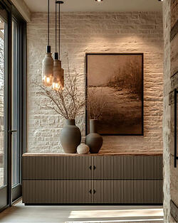 Sideboard mit naturfarbener Lamellenfront unter Wandbild und Pendelleuchten