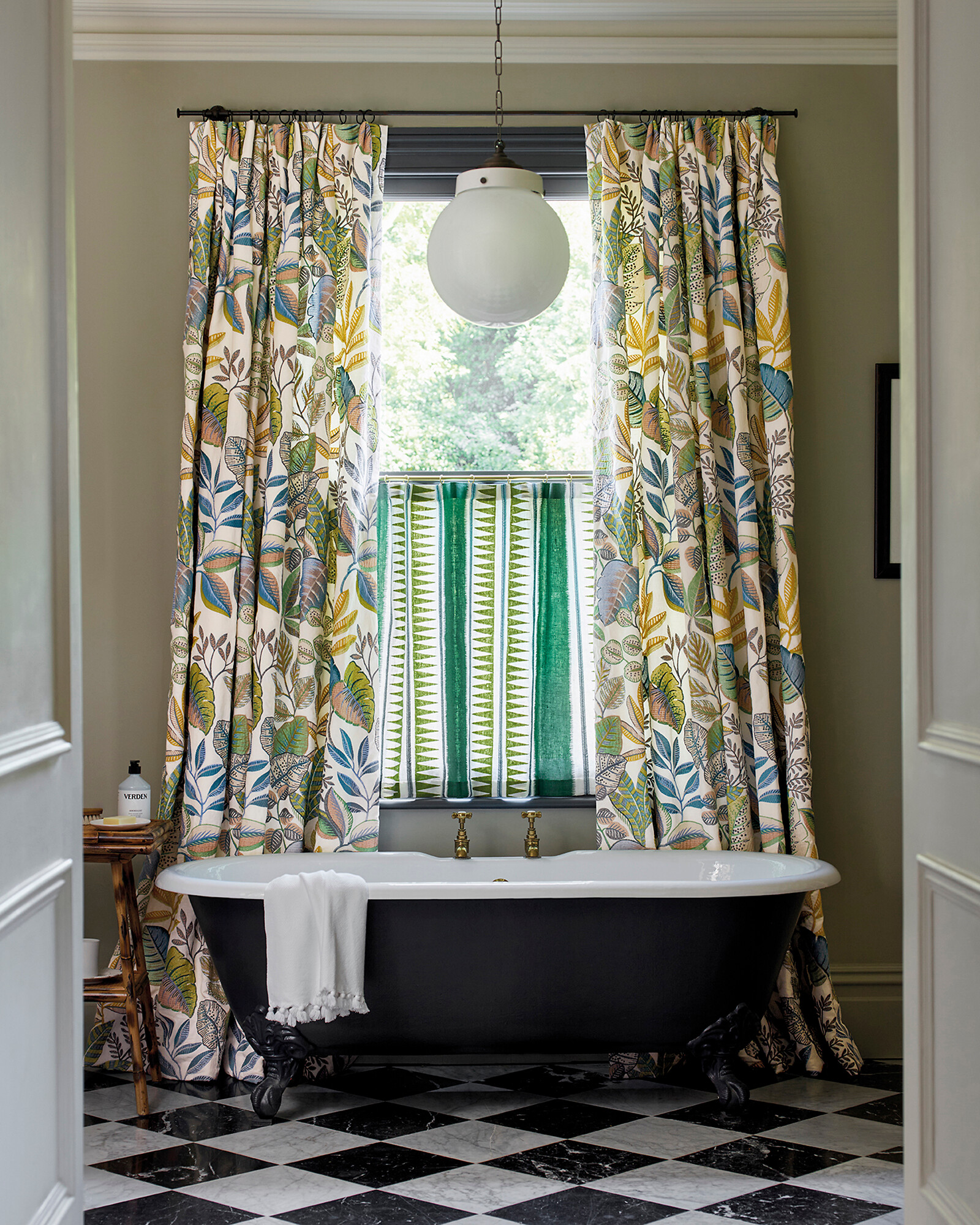 Florale Vorhänge hinter freistehender Badewanne  