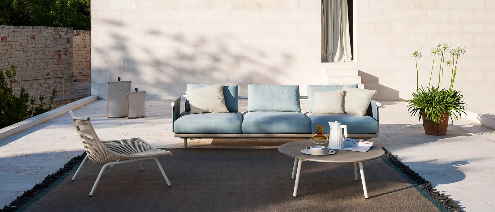 Outdoor-Sofa von Roda in hellem Blau mit Lounge-Sessel und Couchtisch auf moderner Terrasse  
